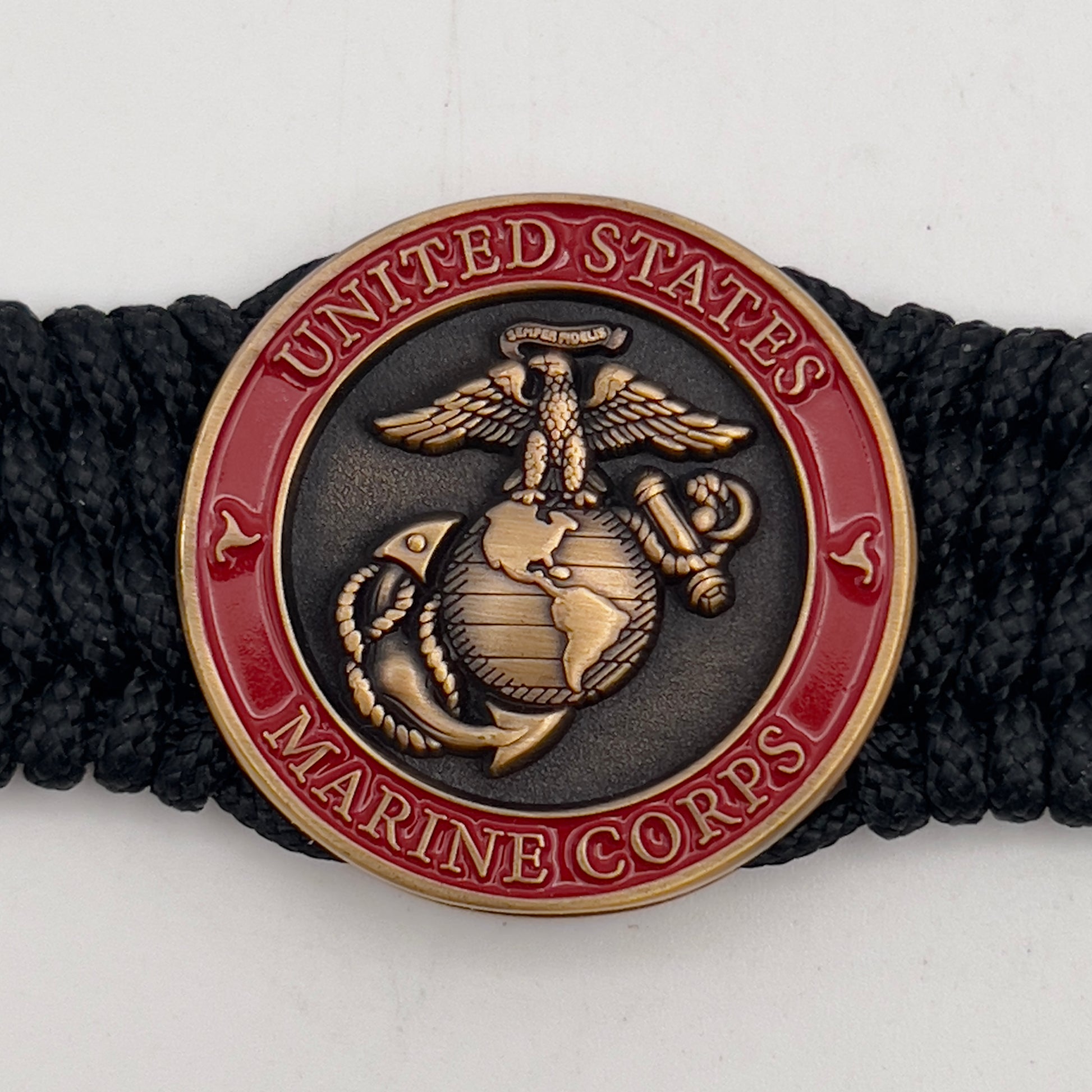 Thin, medium wide, very thin and flexible and comfortable braided United States Marine Corps bracelet featuring a 24K antique gold plated USMC Eagle Globe and Anchor medallion, a black Cobra style tactical buckle and woven with black Type-1 paracord.