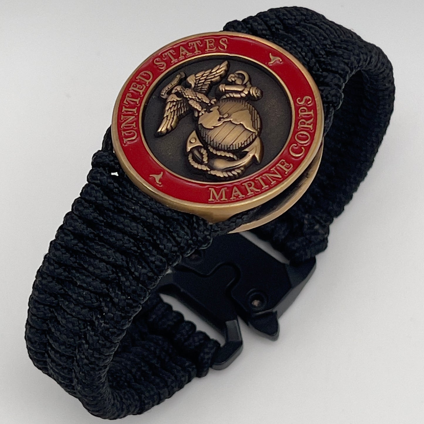 Thin, narrow, flexible and comfortable braided United States Marine Corps bracelet featuring a 24K antique gold plated USMC Eagle Globe and Anchor medallion, a black Cobra style tactical buckle and woven with black Type-1 paracord.