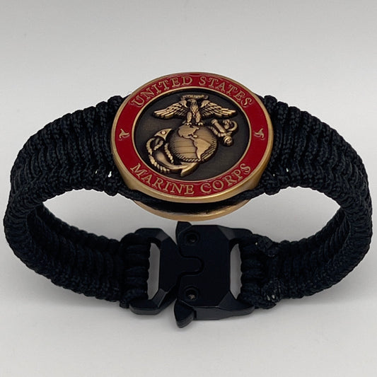 Thin, narrow, flexible and comfortable braided United States Marine Corps bracelet featuring a 24K antique gold plated USMC Eagle Globe and Anchor medallion, a black Cobra style tactical buckle and woven with black Type-1 paracord.