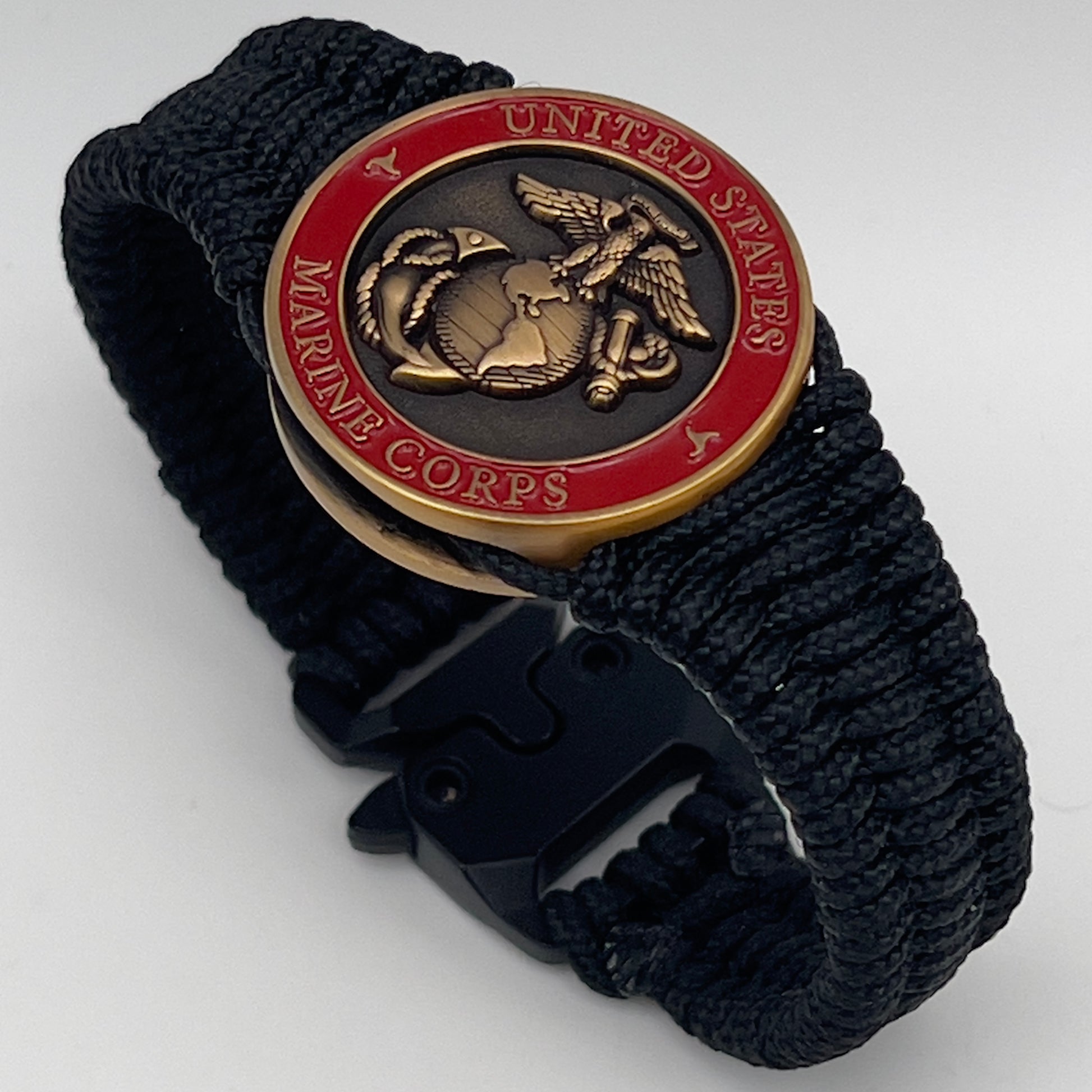 Thin, narrow, flexible and comfortable braided United States Marine Corps bracelet featuring a 24K antique gold plated USMC Eagle Globe and Anchor medallion, a black Cobra style tactical buckle and woven with black Type-1 paracord.