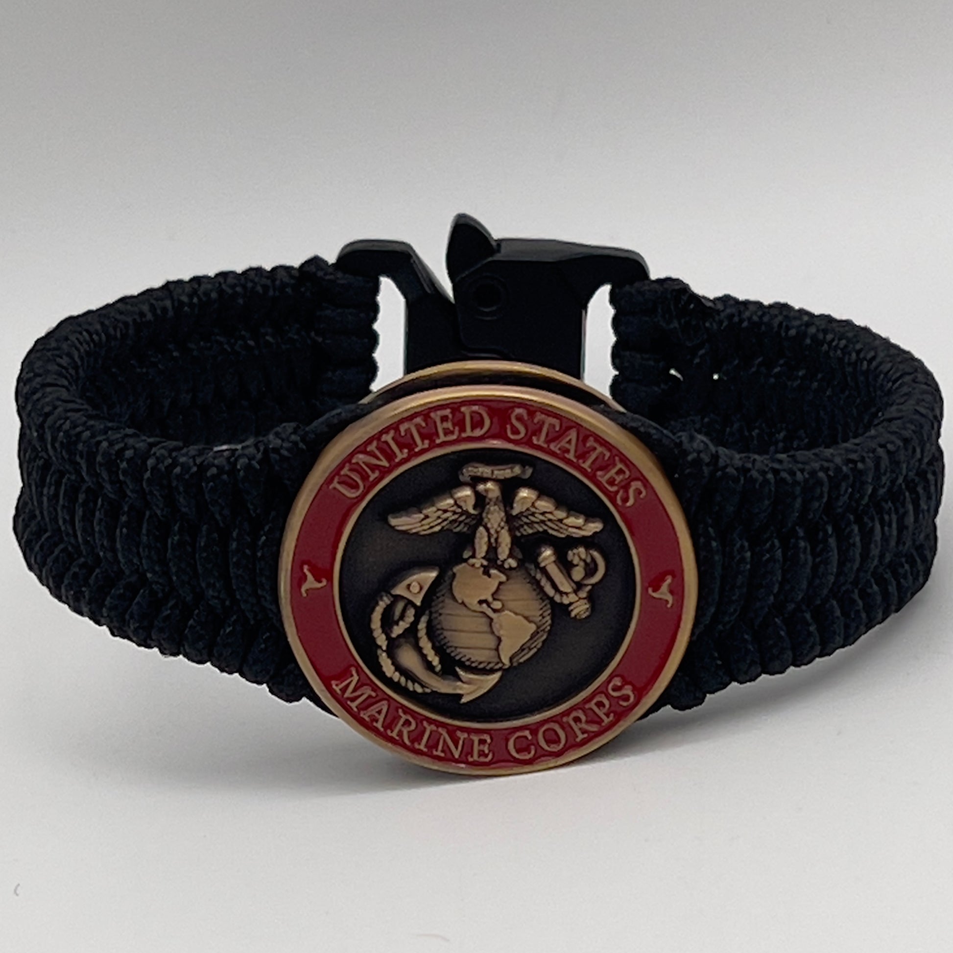 Thin, narrow, flexible and comfortable braided United States Marine Corps bracelet featuring a 24K antique gold plated USMC Eagle Globe and Anchor medallion, a black Cobra style tactical buckle and woven with black Type-1 paracord.