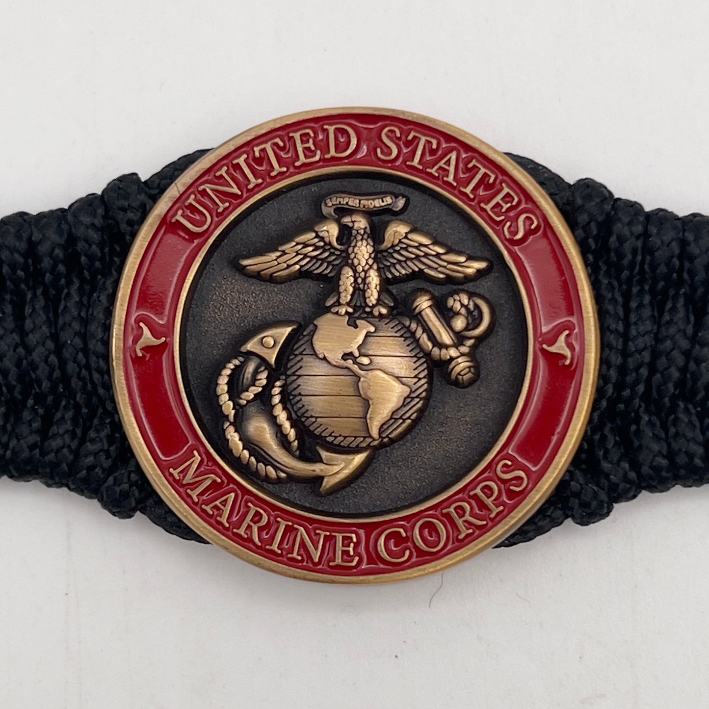 Thin, narrow, flexible and comfortable braided United States Marine Corps bracelet featuring a 24K antique gold plated USMC Eagle Globe and Anchor medallion, a black Cobra style tactical buckle and woven with black Type-1 paracord.