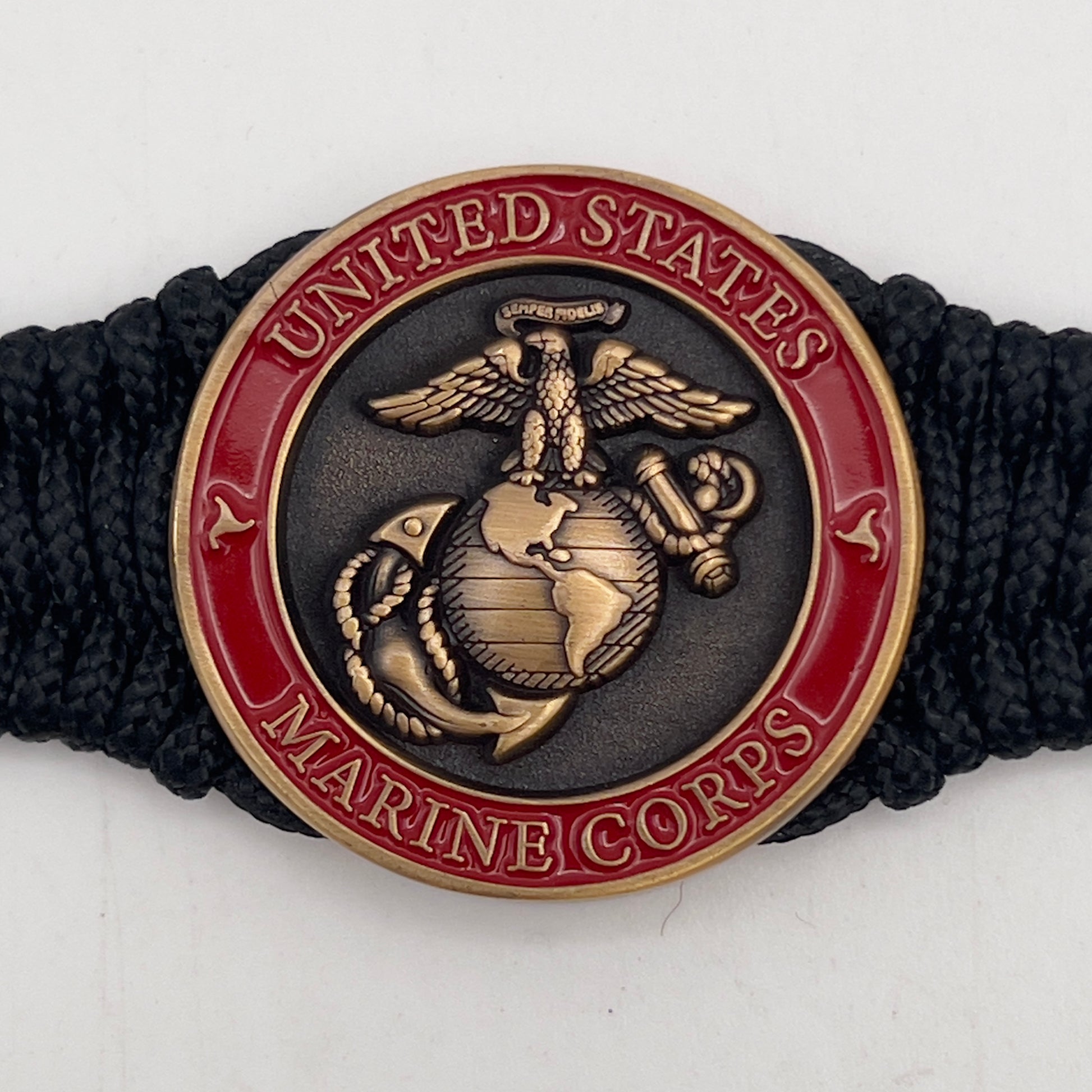 Thin, narrow, flexible and comfortable braided United States Marine Corps bracelet featuring a 24K antique gold plated USMC Eagle Globe and Anchor medallion, a black Cobra style tactical buckle and woven with black Type-1 paracord.
