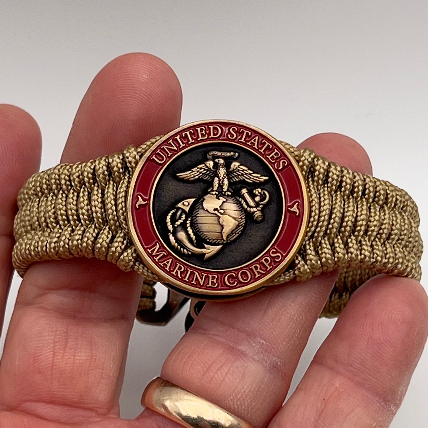 Thin, narrow, very thin and flexible and comfortable braided United States Marine Corps bracelet featuring a 24K antique gold plated USMC Eagle Globe and Anchor medallion, a gold Cobra style tactical buckle and woven with gold Type-1 paracord.