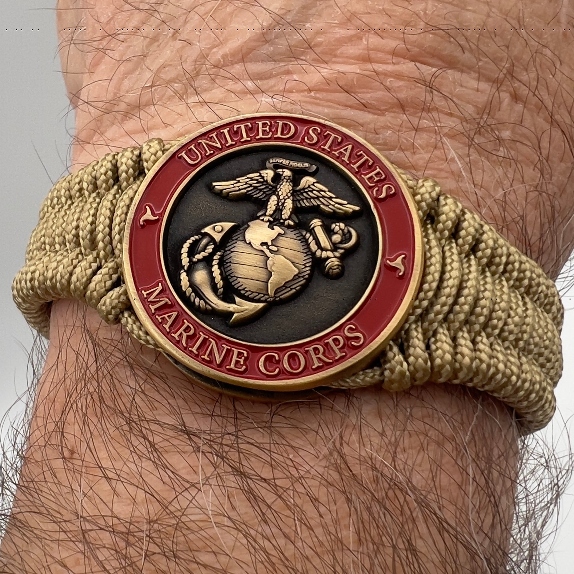 Thin, narrow, very thin and flexible and comfortable braided United States Marine Corps bracelet featuring a 24K antique gold plated USMC Eagle Globe and Anchor medallion, a gold Cobra style tactical buckle and woven with gold Type-1 paracord.