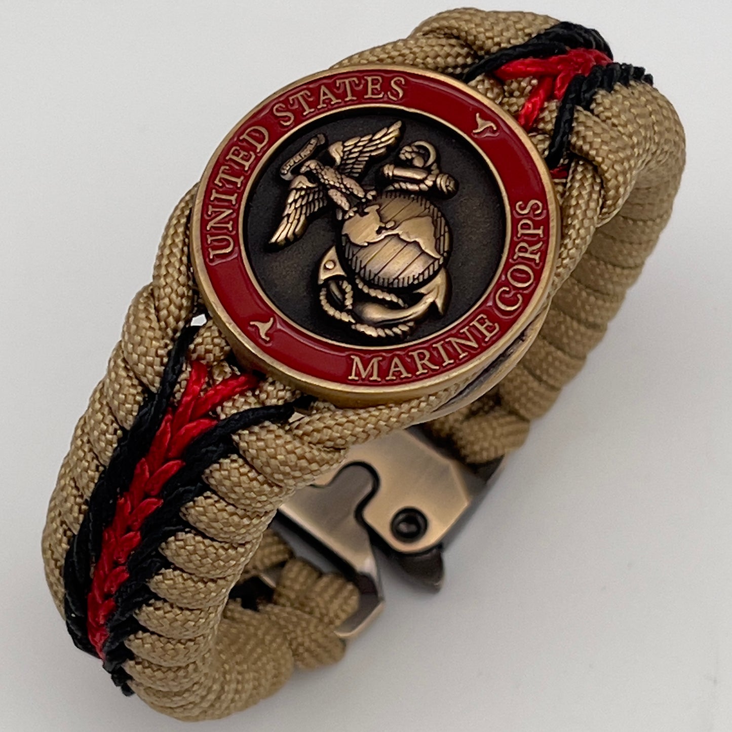 Thick, medium width, rigid and comfortable braided United States Marine Corps bracelet featuring a 24K antique gold plated USMC Eagle Globe and Anchor medallion, a gold Cobra style tactical buckle and woven with gold 550 paracord and Imperial red and black micro cord.