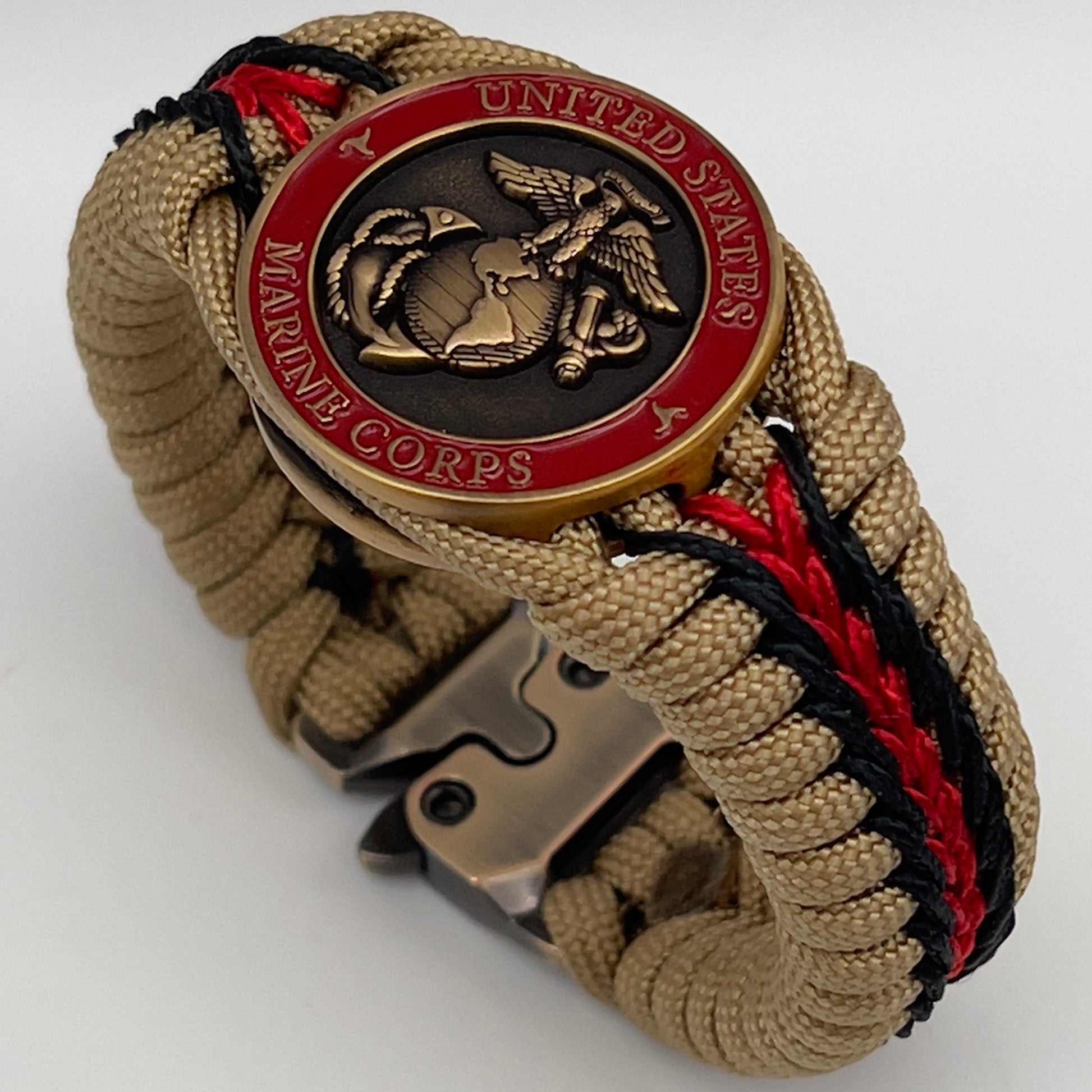 Thick, medium width, rigid and comfortable braided United States Marine Corps bracelet featuring a 24K antique gold plated USMC Eagle Globe and Anchor medallion, a gold Cobra style tactical buckle and woven with gold 550 paracord and Imperial red and black micro cord.