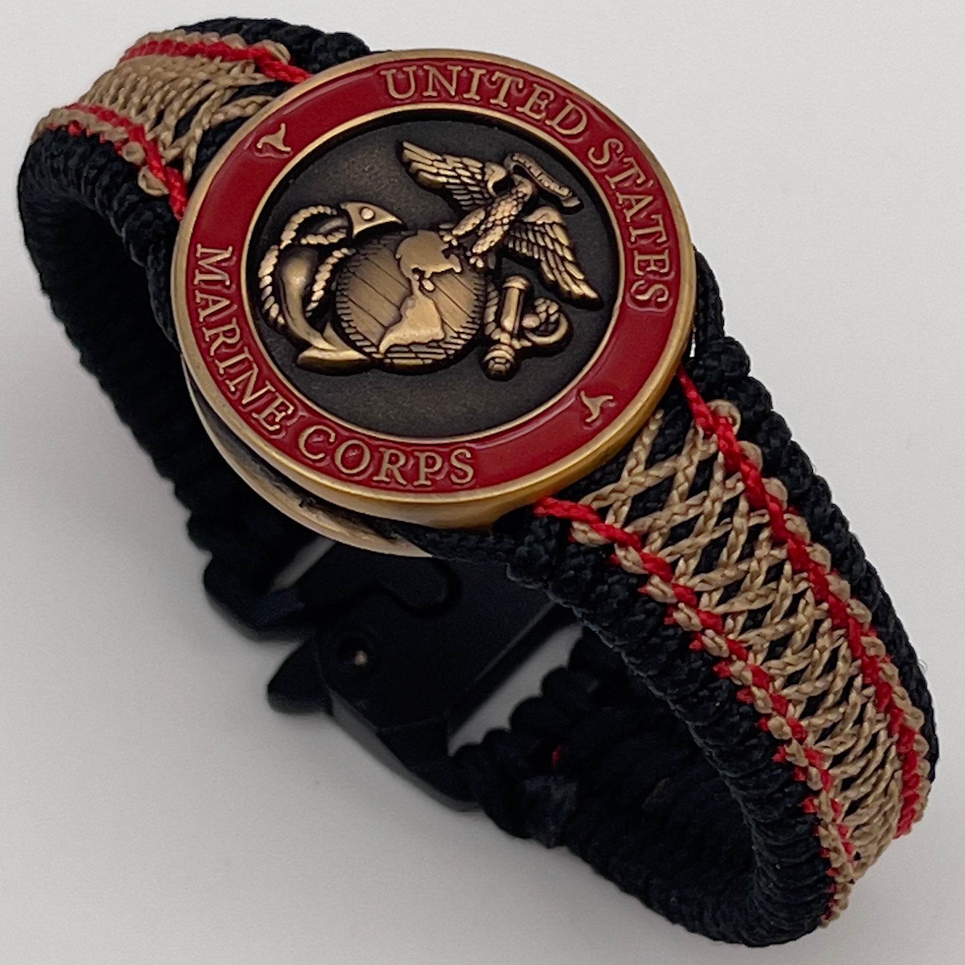 Thin, narrow, very thin and flexible and comfortable braided United States Marine Corps bracelet featuring a 24K antique gold plated USMC Eagle Globe and Anchor medallion, a black Cobra style tactical buckle and woven with black Type-1 paracord and Imperial Red and GOld nano cord.