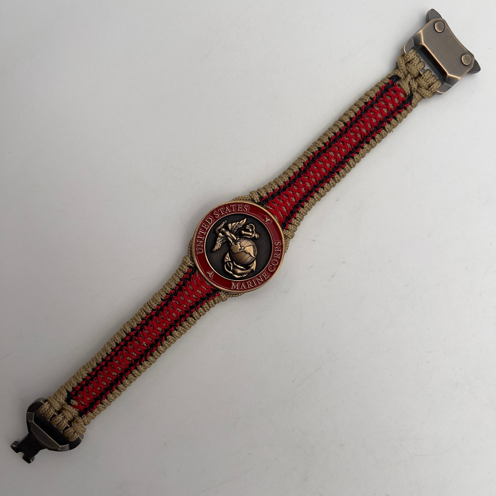 Thin, narrow, very thin and flexible and comfortable braided United States Marine Corps bracelet featuring a 24K antique gold plated USMC Eagle Globe and Anchor medallion, a gold Cobra style tactical buckle and woven with gold Type-1 paracord and Imperial Red and Black nano cord.