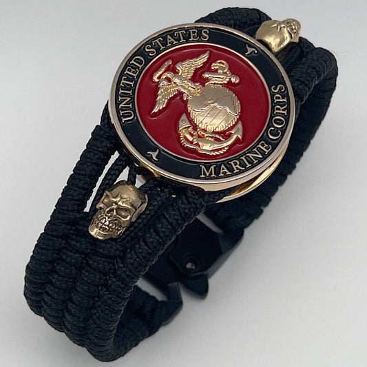 Thin, medium width, flexible and comfortable braided United States Marine Corps bracelet featuring a 24K gold plated USMC officer Eagle Globe and Anchor medallion, two gold plated skulls, a black Cobra style tactical buckle and woven with black Type-1 paracord.