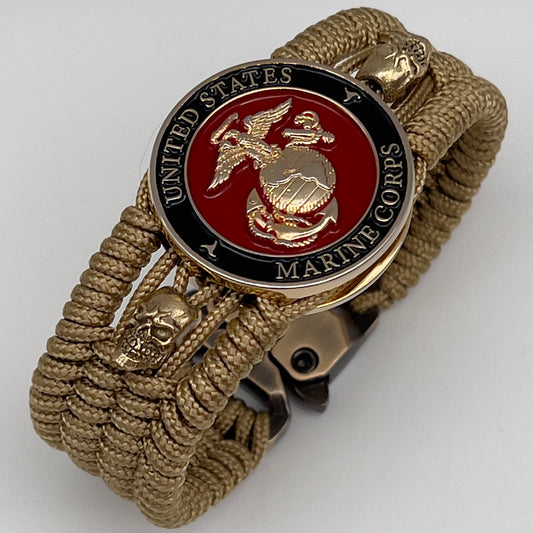 Thin, medium width, flexible and comfortable braided United States Marine Corps bracelet featuring a 24K gold plated USMC officer Eagle Globe and Anchor medallion, two gold plated skulls, a gold Cobra style tactical buckle and woven with gold Type-1 paracord.