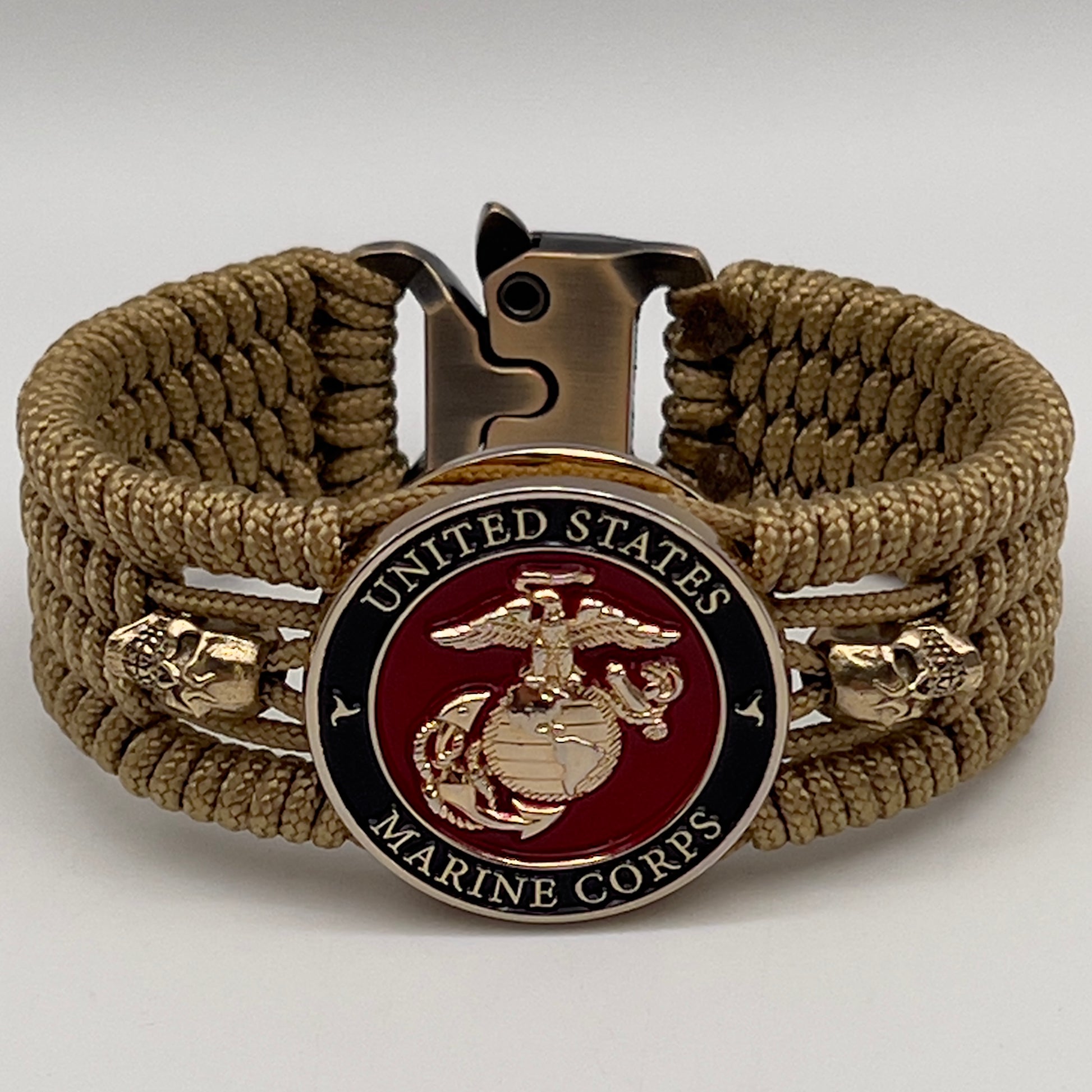Thin, medium width, flexible and comfortable braided United States Marine Corps bracelet featuring a 24K gold plated USMC officer Eagle Globe and Anchor medallion, two gold plated skulls, a gold Cobra style tactical buckle and woven with gold Type-1 paracord.