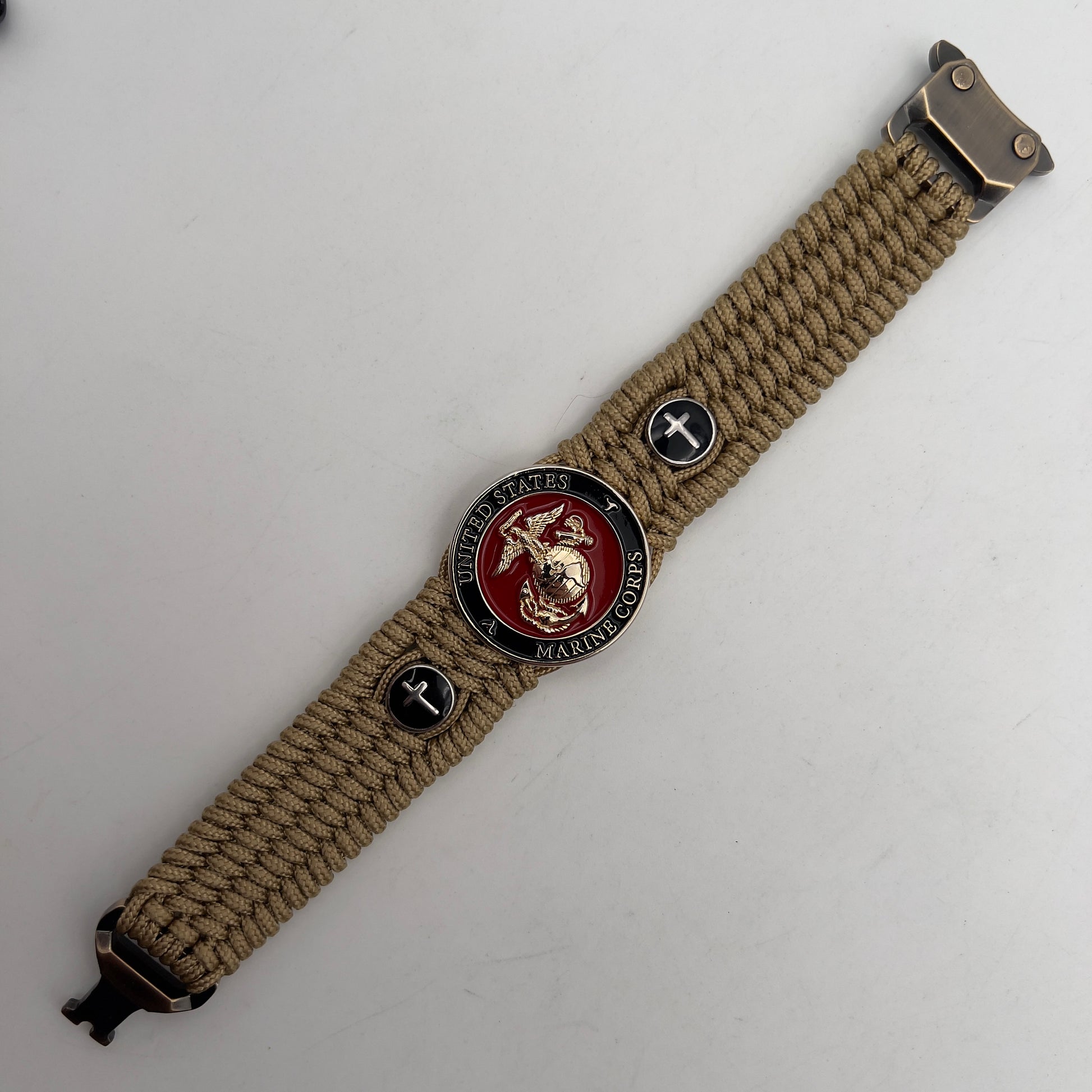 Thin, medium width, flexible and comfortable braided United States Marine Corps bracelet featuring a 24K gold plated USMC officer Eagle Globe and Anchor medallion, two Christian crosses, a gold Cobra style tactical buckle and woven with gold Type-1 paracord.
