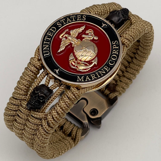 Thin, medium width, flexible and comfortable braided United States Marine Corps bracelet featuring a 24K gold plated USMC officer Eagle Globe and Anchor medallion, two black micro skulls, a gold Cobra style tactical buckle and woven with gold Type-1 paracord.