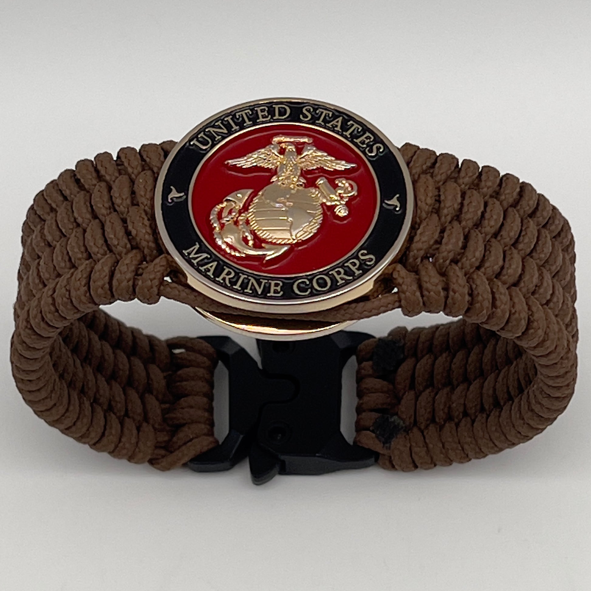 Thin, medium width, flexible and comfortable braided United States Marine Corps bracelet featuring a 24K gold plated USMC officer Eagle Globe and Anchor medallion, a gold Cobra style tactical buckle and woven with Coyote Brown Type-1 paracord.