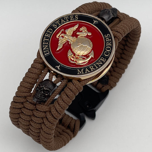Thin, medium width, flexible and comfortable braided United States Marine Corps bracelet featuring a 24K gold plated USMC officer Eagle Globe and Anchor medallion, two black micro skulls, a black Cobra style tactical buckle and woven with Coyote Brown Type-1 paracord.