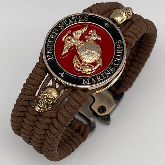 Thin, medium width, flexible and comfortable braided United States Marine Corps bracelet featuring a 24K gold plated USMC officer Eagle Globe and Anchor medallion, two gold plated skulls, a gold Cobra style tactical buckle and woven with Coyote Brown Type-1 paracord.