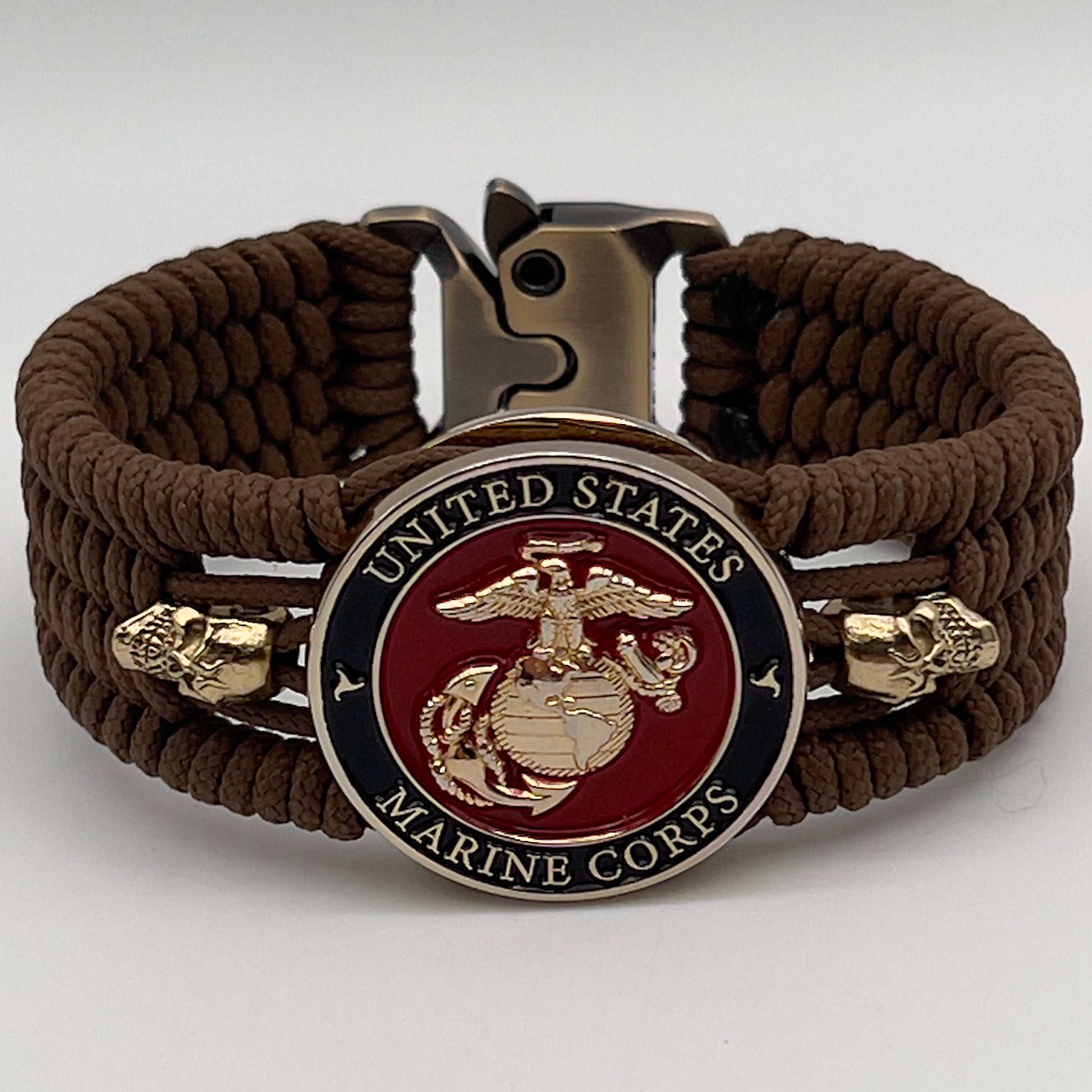 Thin, medium width, flexible and comfortable braided United States Marine Corps bracelet featuring a 24K gold plated USMC officer Eagle Globe and Anchor medallion, two gold plated skulls, a gold Cobra style tactical buckle and woven with Coyote Brown Type-1 paracord.