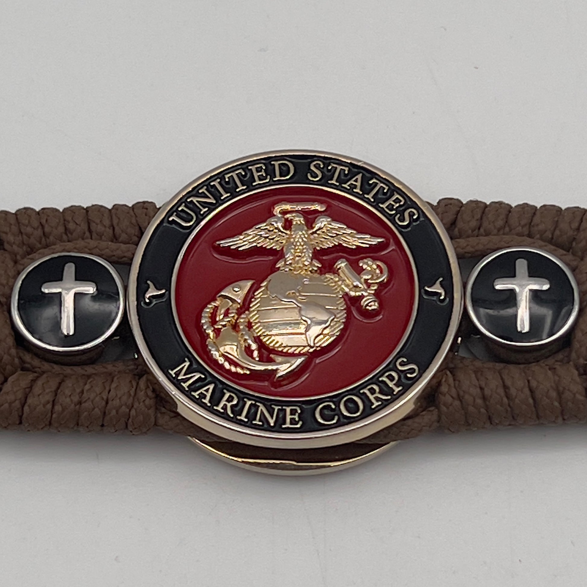 Thin, medium width, flexible and comfortable braided United States Marine Corps bracelet featuring a 24K gold plated USMC officer Eagle Globe and Anchor medallion, two Christian crosses, a black Cobra style tactical buckle and woven with Coyote Brown Type-1 paracord.
