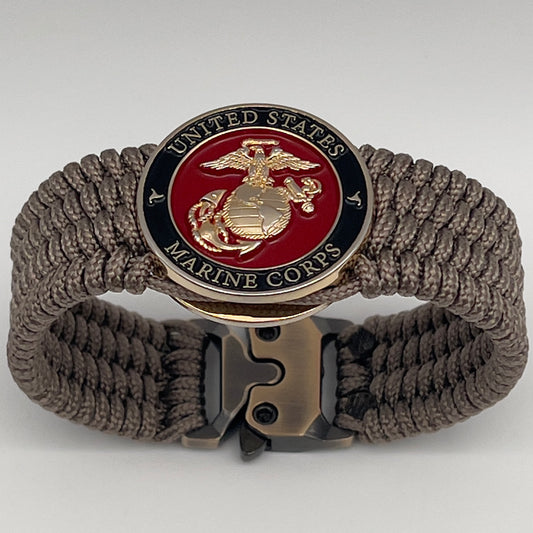 Thin, medium width, flexible and comfortable braided United States Marine Corps bracelet featuring a 24K gold plated USMC officer Eagle Globe and Anchor medallion, a gold Cobra style tactical buckle and woven with Tan Type-1 paracord.