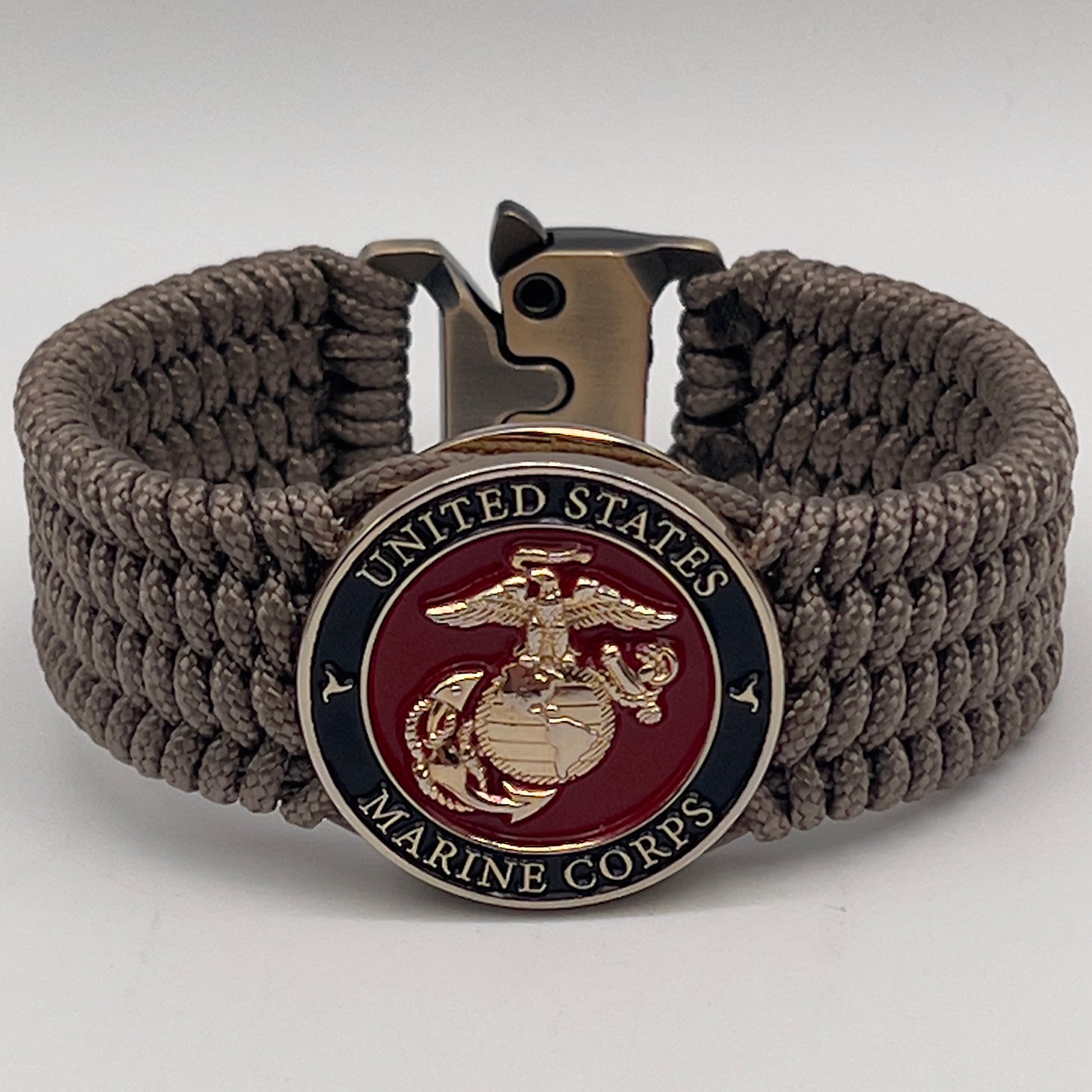 Thin, medium width, flexible and comfortable braided United States Marine Corps bracelet featuring a 24K gold plated USMC officer Eagle Globe and Anchor medallion, a gold Cobra style tactical buckle and woven with Tan Type-1 paracord.