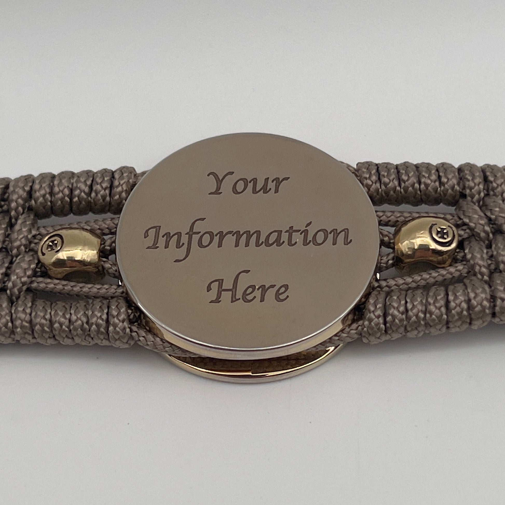 Thin, medium width, flexible and comfortable braided United States Marine Corps bracelet featuring a 24K gold plated USMC officer Eagle Globe and Anchor medallion, two gold plated skulls, a gold Cobra style tactical buckle and woven with Tan Type-1 paracord.