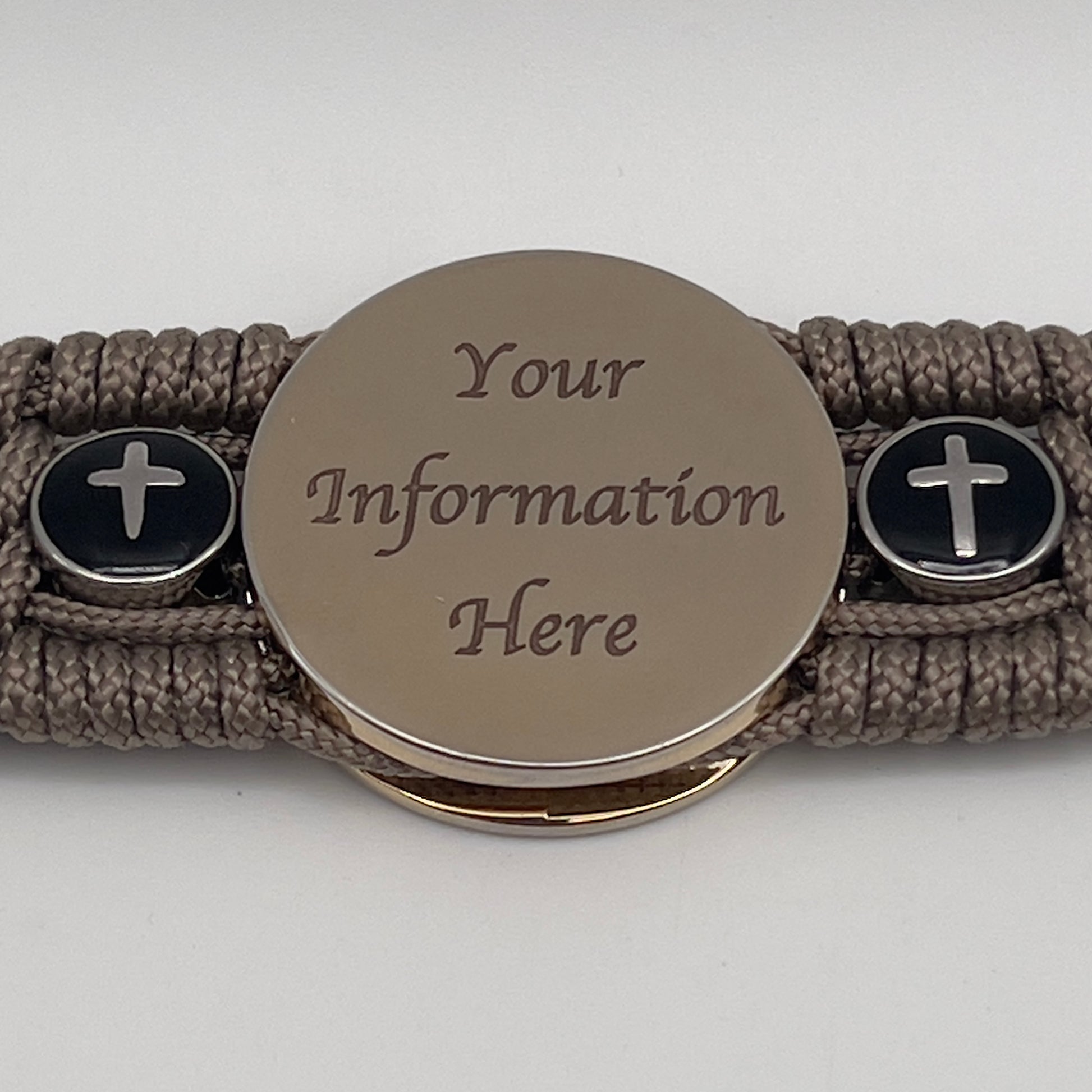 Thin, medium width, flexible and comfortable braided United States Marine Corps bracelet featuring a 24K gold plated USMC officer Eagle Globe and Anchor medallion, two Christian crosses, a black Cobra style tactical buckle and woven with Tan Type-1 paracord.