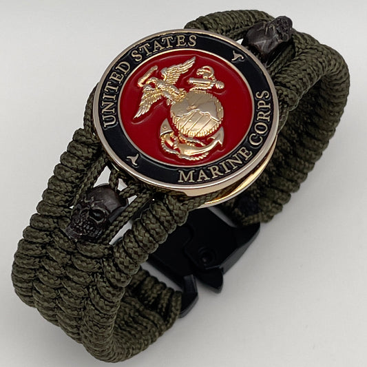 Thin, medium width, flexible and comfortable braided United States Marine Corps bracelet featuring a 24K gold plated USMC officer Eagle Globe and Anchor medallion, two black micro skulls, a black Cobra style tactical buckle and woven with Olive Drab Type-1 paracord.