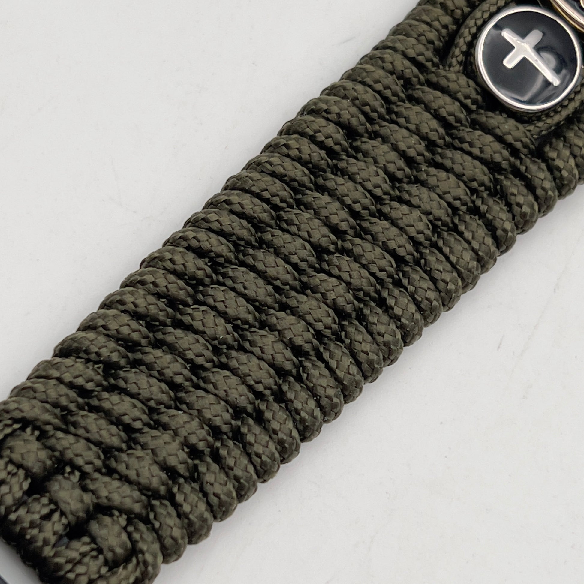Thin, medium width, flexible and comfortable braided United States Marine Corps bracelet featuring a 24K gold plated USMC officer Eagle Globe and Anchor medallion, two Christian crosses, a black Cobra style tactical buckle and woven with Olive Drab Type-1 paracord.