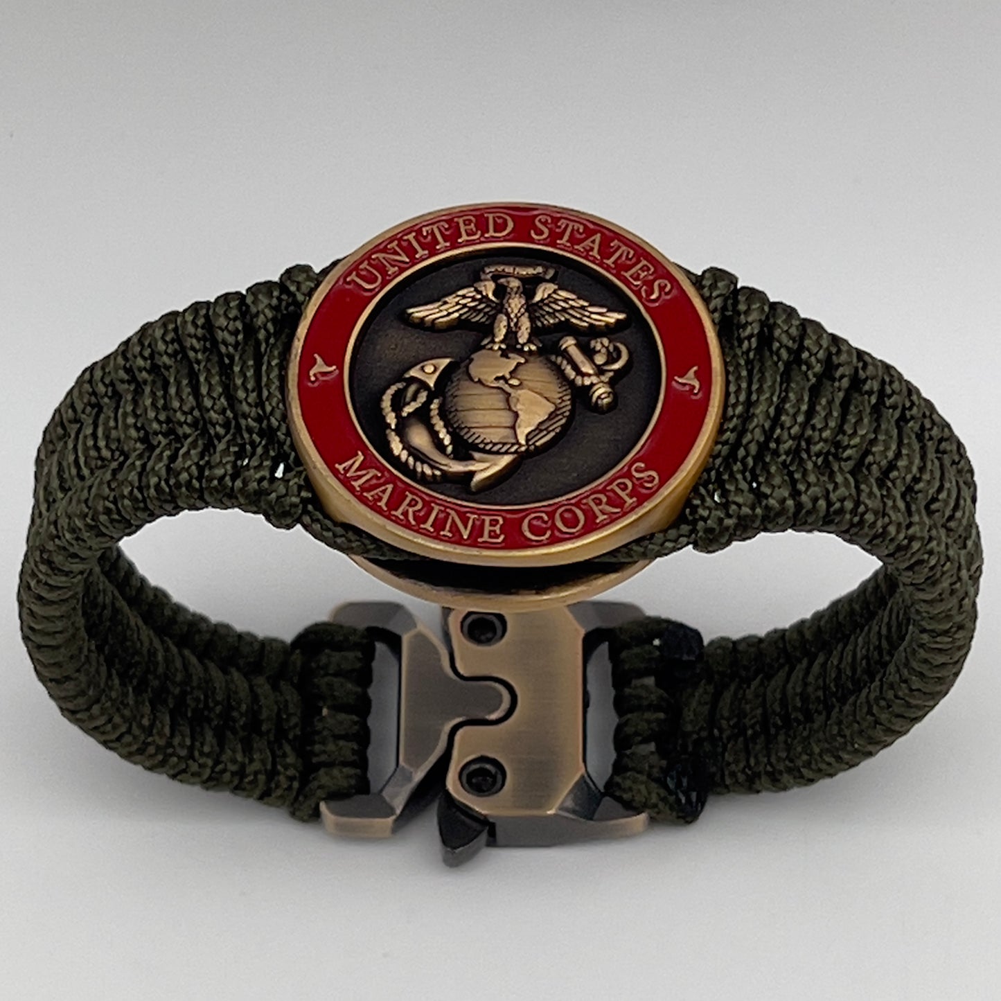 Thin, narrow, flexible and comfortable braided United States Marine Corps bracelet featuring a 24K antique gold plated USMC Eagle Globe and Anchor medallion, a gold Cobra style tactical buckle and woven with Olive Drab Type-1 paracord.