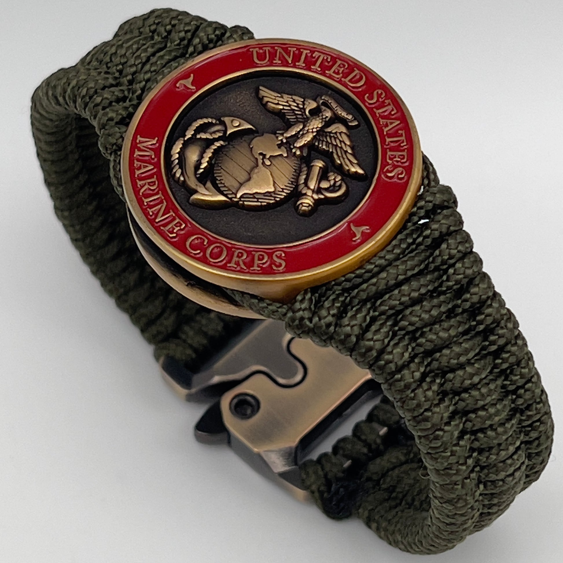 Thin, narrow, flexible and comfortable braided United States Marine Corps bracelet featuring a 24K antique gold plated USMC Eagle Globe and Anchor medallion, a gold Cobra style tactical buckle and woven with Olive Drab Type-1 paracord.