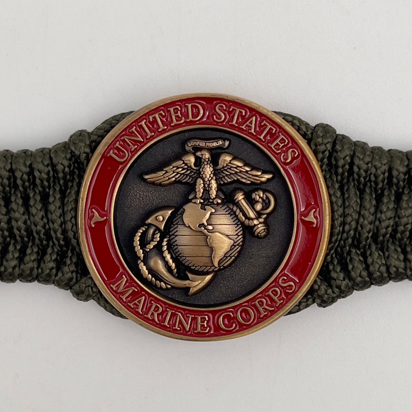 Thin, narrow, flexible and comfortable braided United States Marine Corps bracelet featuring a 24K antique gold plated USMC Eagle Globe and Anchor medallion, a gold Cobra style tactical buckle and woven with Olive Drab Type-1 paracord.