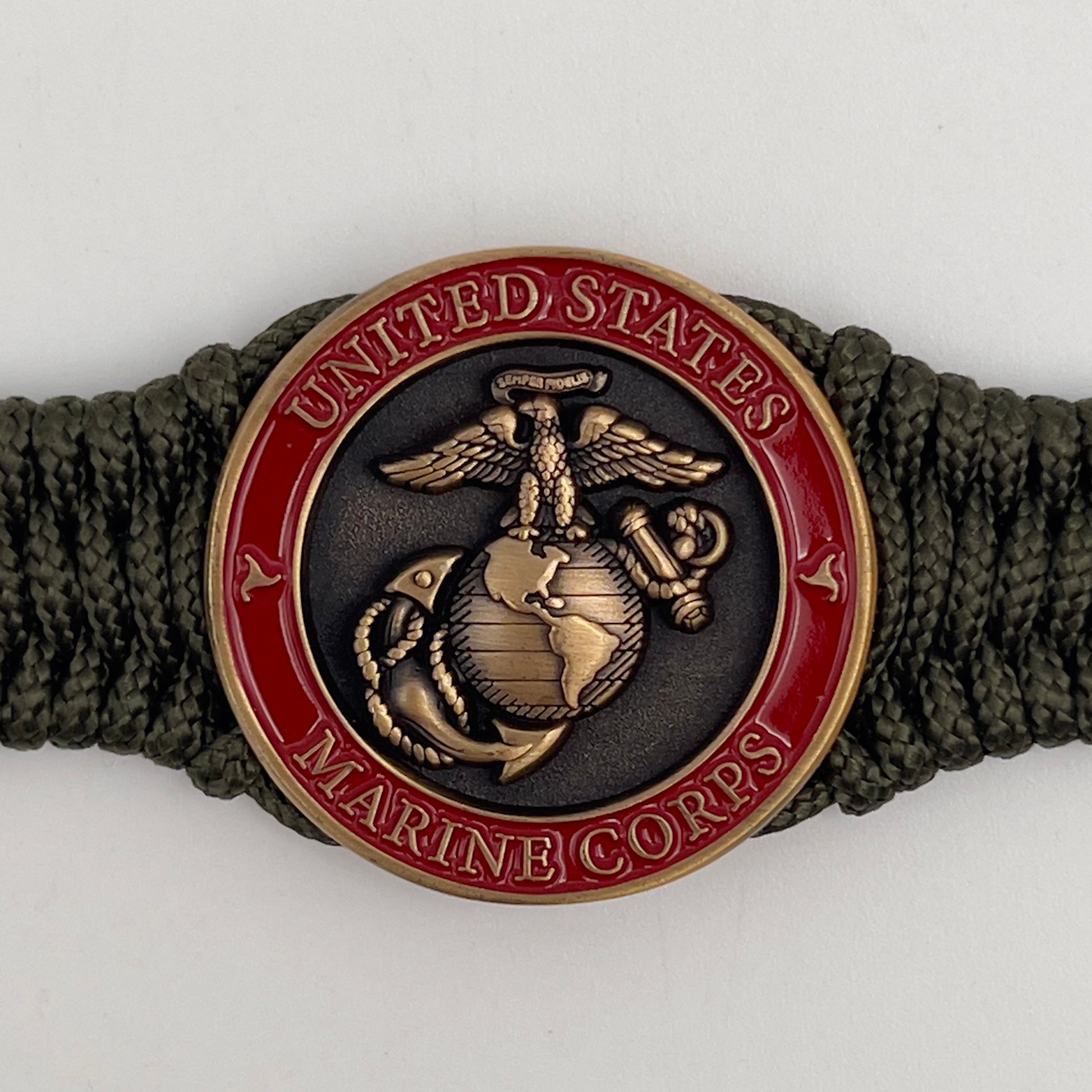 Thin, narrow, flexible and comfortable braided United States Marine Corps bracelet featuring a 24K antique gold plated USMC Eagle Globe and Anchor medallion, a gold Cobra style tactical buckle and woven with Olive Drab Type-1 paracord.