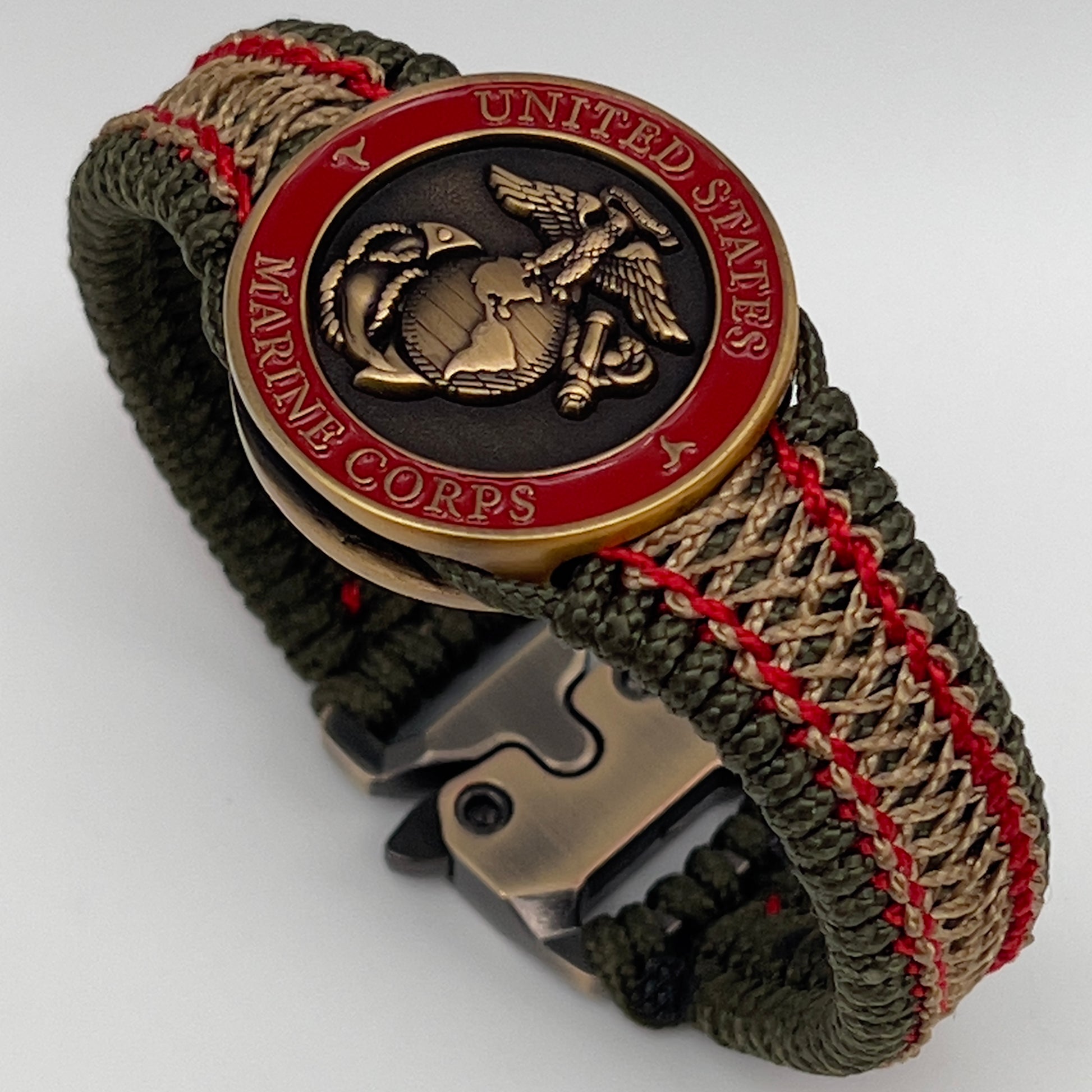 Thin, narrow, flexible and comfortable braided United States Marine Corps bracelet featuring a 24K antique gold plated USMC Eagle Globe and Anchor medallion, a gold Cobra style tactical buckle and woven with Olive Drab Type-1 paracord and Imperial Red and Gold nano cord.