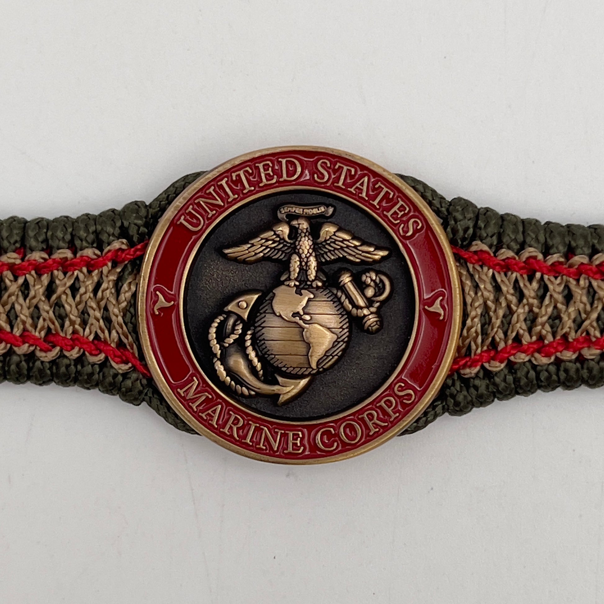 Thin, narrow, flexible and comfortable braided United States Marine Corps bracelet featuring a 24K antique gold plated USMC Eagle Globe and Anchor medallion, a gold Cobra style tactical buckle and woven with Olive Drab Type-1 paracord and Imperial Red and Gold nano cord.