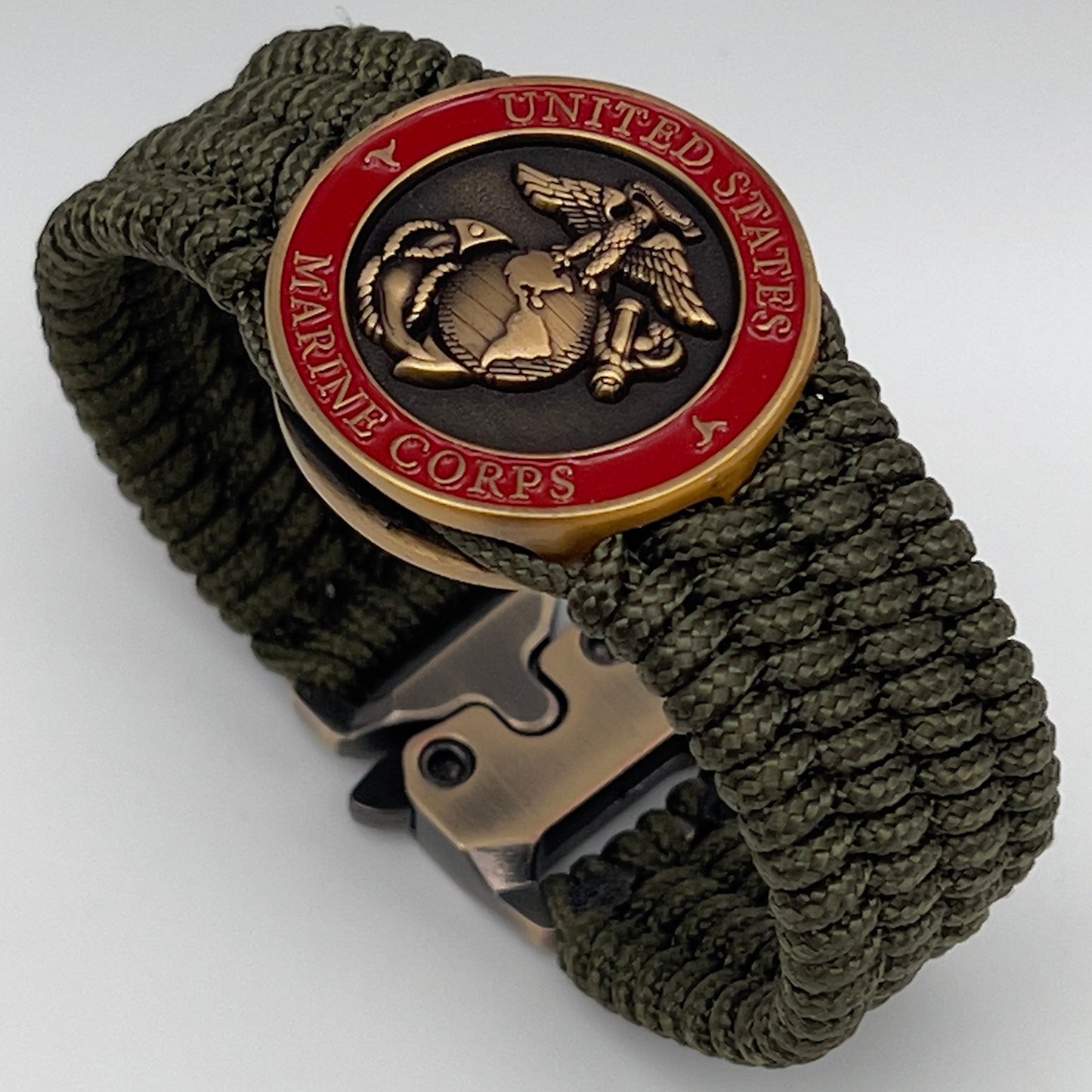 Thin, medium wide, flexible and comfortable braided United States Marine Corps bracelet featuring a 24K antique gold plated USMC Eagle Globe and Anchor medallion, a gold Cobra style tactical buckle and woven with Olive Drab Type-1 paracord.