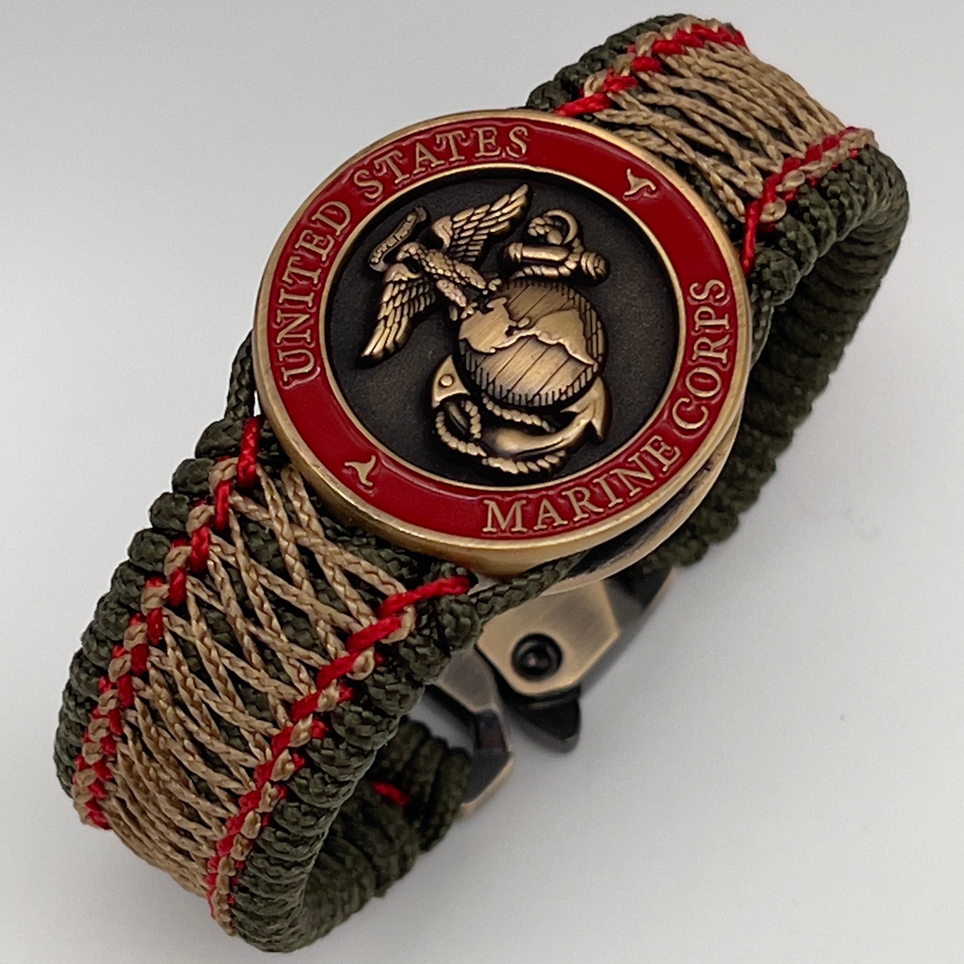 Thin, medium width, flexible and comfortable braided United States Marine Corps bracelet featuring a 24K antique gold plated USMC Eagle Globe and Anchor medallion, a gold Cobra style tactical buckle and woven with Olive Drab Type-1 paracord and Imperial Red and Gold nano cord.