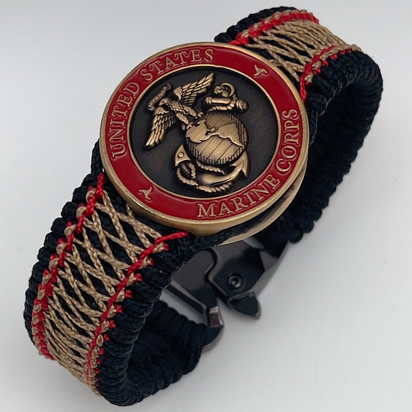 Thin, medium width, flexible and comfortable braided United States Marine Corps bracelet featuring a 24K antique gold plated USMC Eagle Globe and Anchor medallion, a black Cobra style tactical buckle and woven with black Type-1 paracord and Imperial Red and Gold nano cord.