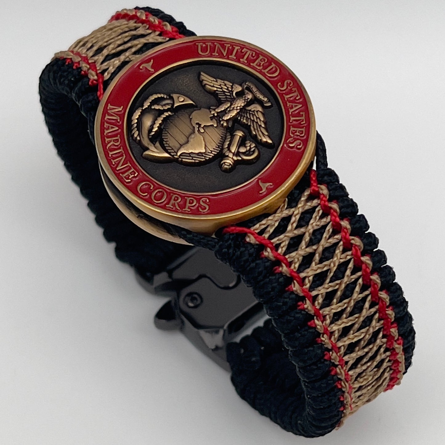 Thin, medium width, flexible and comfortable braided United States Marine Corps bracelet featuring a 24K antique gold plated USMC Eagle Globe and Anchor medallion, a black Cobra style tactical buckle and woven with black Type-1 paracord and Imperial Red and Gold nano cord.