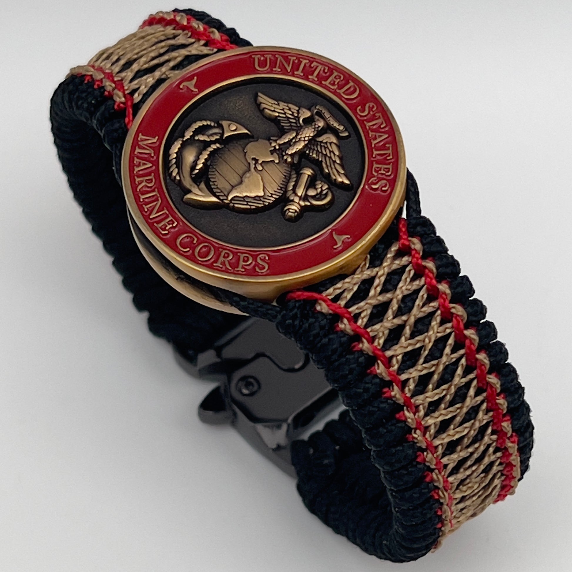 Thin, medium width, flexible and comfortable braided United States Marine Corps bracelet featuring a 24K antique gold plated USMC Eagle Globe and Anchor medallion, a black Cobra style tactical buckle and woven with black Type-1 paracord and Imperial Red and Gold nano cord.