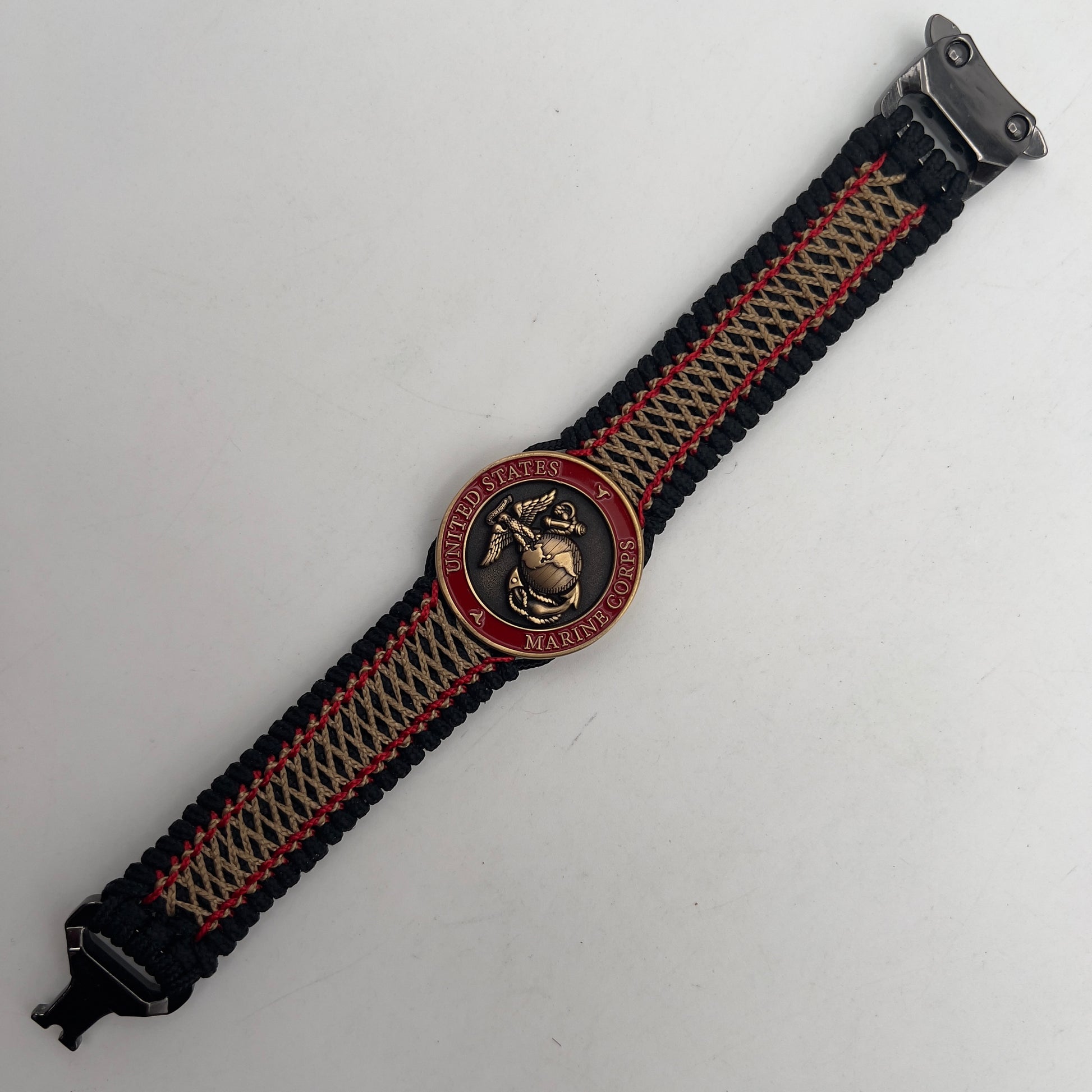 Thin, medium width, flexible and comfortable braided United States Marine Corps bracelet featuring a 24K antique gold plated USMC Eagle Globe and Anchor medallion, a black Cobra style tactical buckle and woven with black Type-1 paracord and Imperial Red and Gold nano cord.