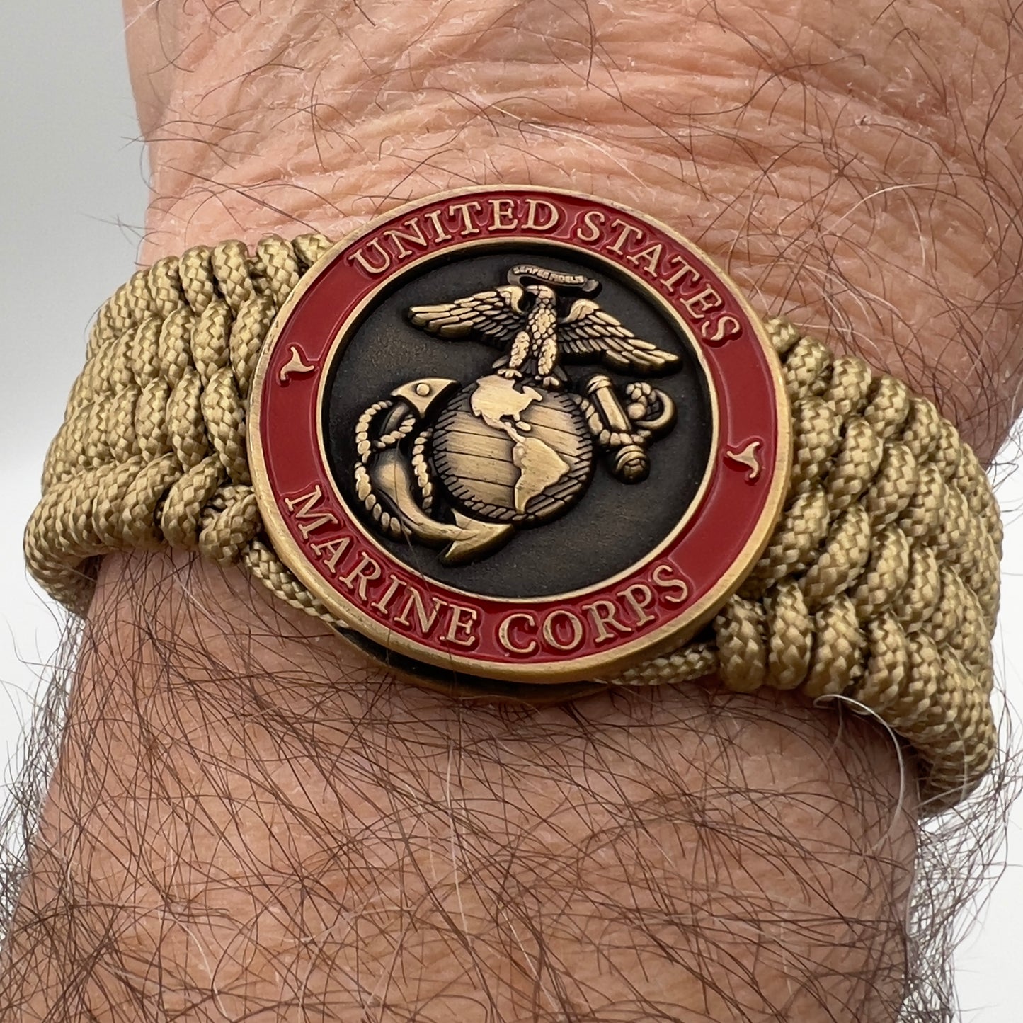 Thin, wide, flexible and comfortable braided United States Marine Corps bracelet featuring a 24K antique gold plated USMC Eagle Globe and Anchor medallion, a gold Cobra style tactical buckle and woven with gold Type-1 paracord.