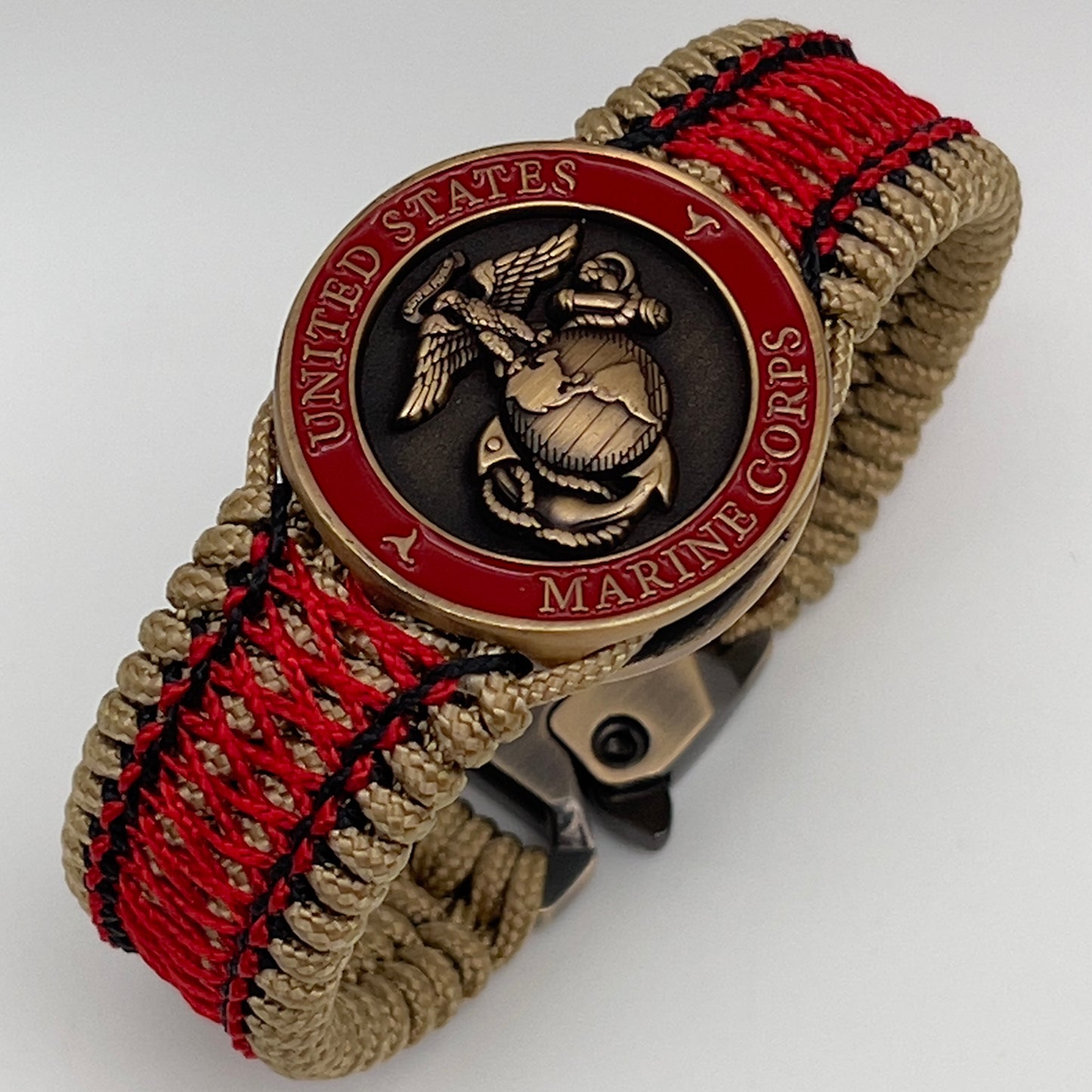 Thin, medium width, flexible and comfortable braided United States Marine Corps bracelet featuring a 24K antique gold plated USMC Eagle Globe and Anchor medallion, a gold Cobra style tactical buckle and woven with gold Type-1 paracord and Imperial Red and Black nano cord.