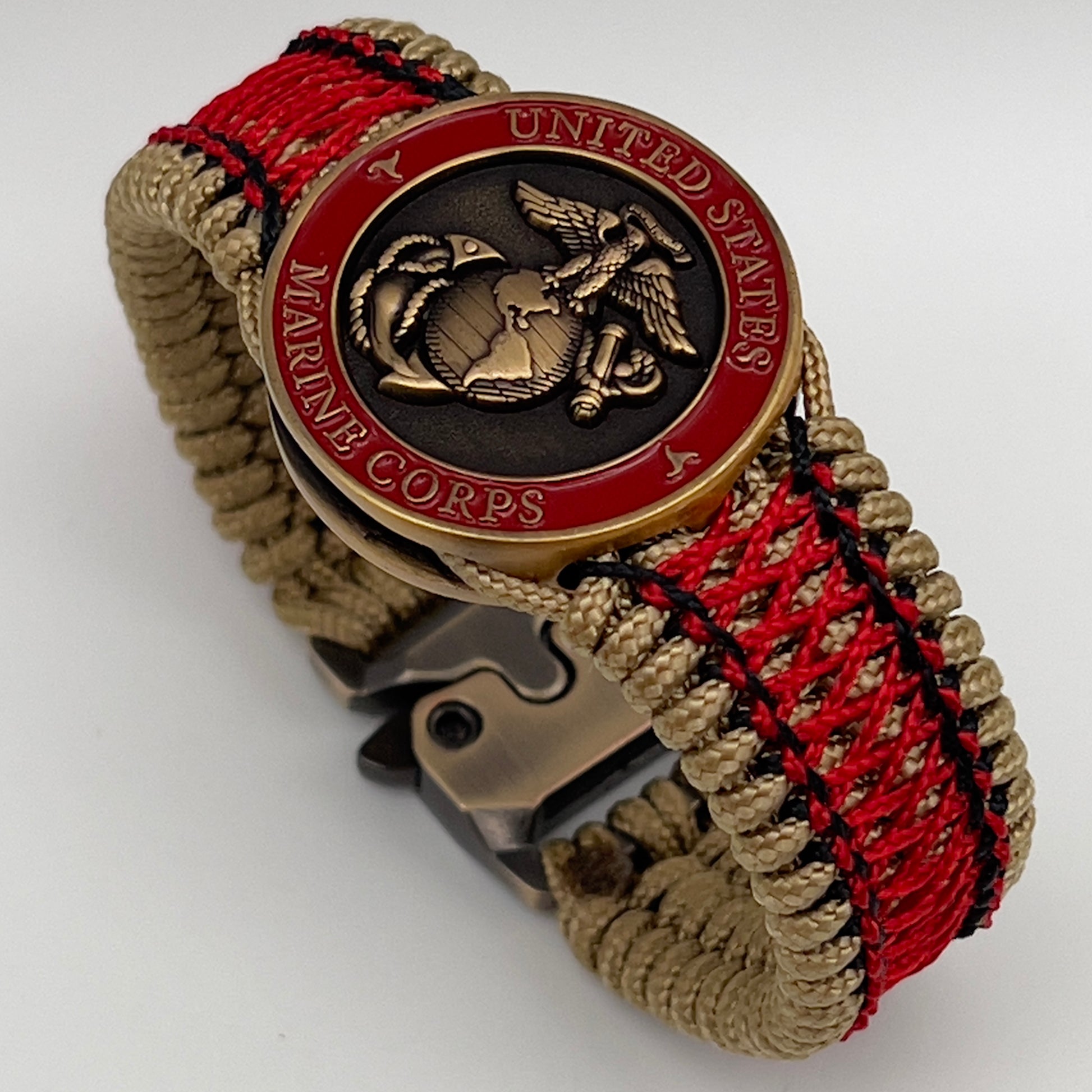 Thin, medium width, flexible and comfortable braided United States Marine Corps bracelet featuring a 24K antique gold plated USMC Eagle Globe and Anchor medallion, a gold Cobra style tactical buckle and woven with gold Type-1 paracord and Imperial Red and Black nano cord.