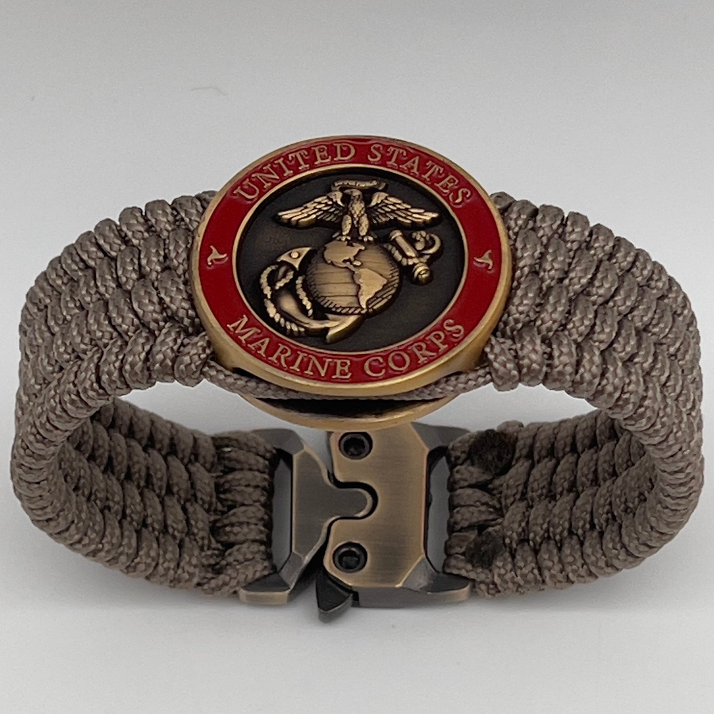 Thin, medium wide, flexible and comfortable braided United States Marine Corps bracelet featuring a 24K antique gold plated USMC Eagle Globe and Anchor medallion, a gold Cobra style tactical buckle and woven with Tan Type-1 paracord.