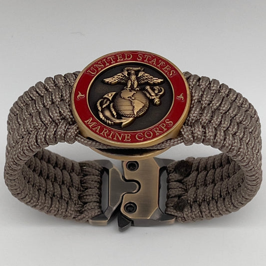 Thin, medium wide, flexible and comfortable braided United States Marine Corps bracelet featuring a 24K antique gold plated USMC Eagle Globe and Anchor medallion, a gold Cobra style tactical buckle and woven with Tan Type-1 paracord.
