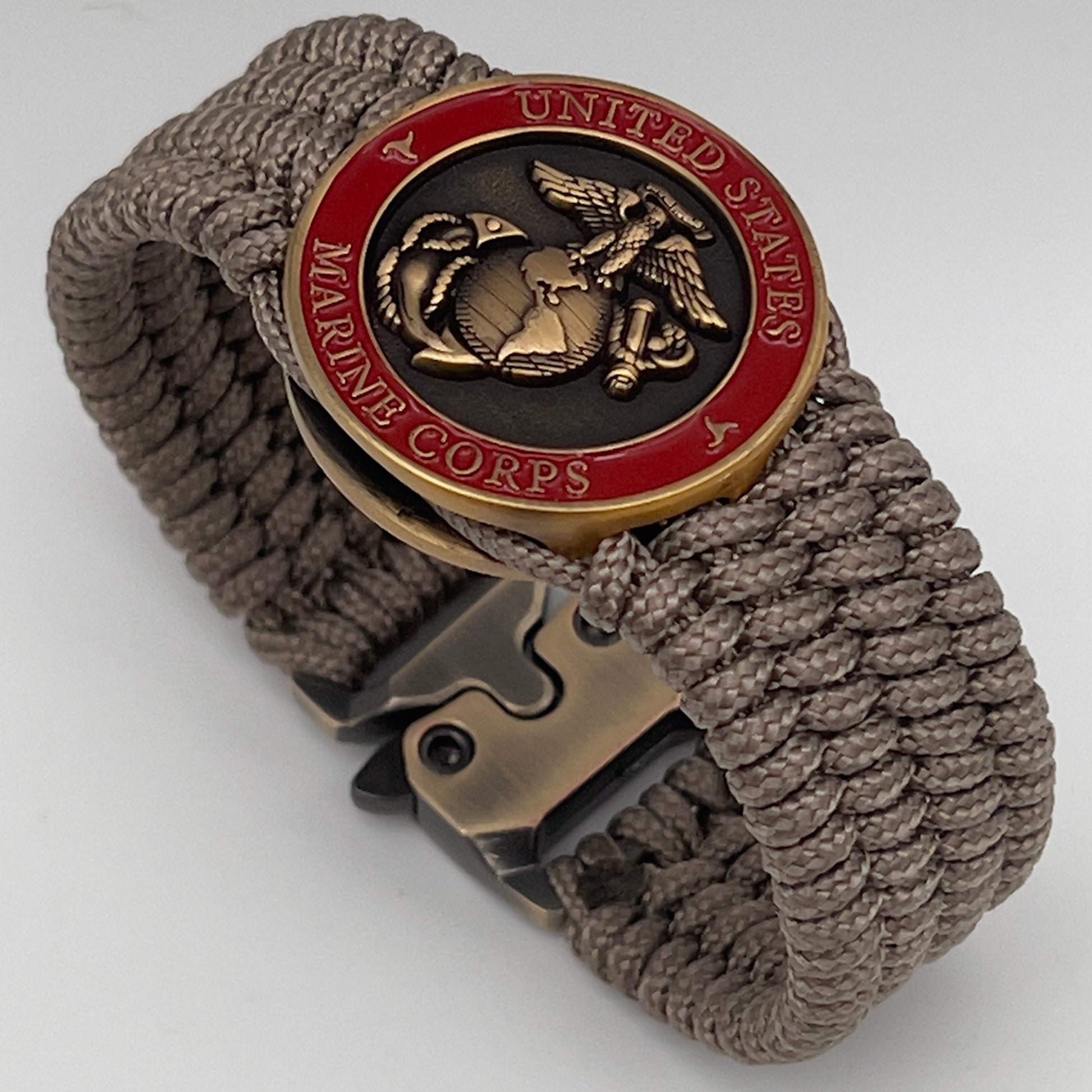 Thin, medium wide, flexible and comfortable braided United States Marine Corps bracelet featuring a 24K antique gold plated USMC Eagle Globe and Anchor medallion, a gold Cobra style tactical buckle and woven with Tan Type-1 paracord.