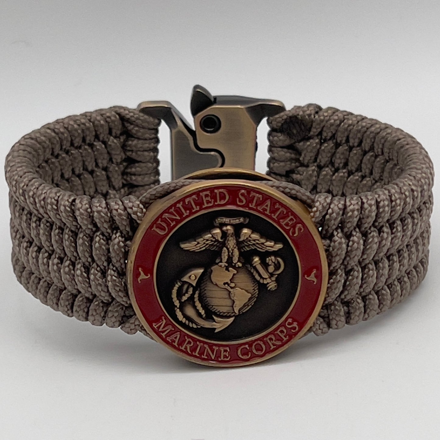 Thin, medium wide, flexible and comfortable braided United States Marine Corps bracelet featuring a 24K antique gold plated USMC Eagle Globe and Anchor medallion, a gold Cobra style tactical buckle and woven with Tan Type-1 paracord.