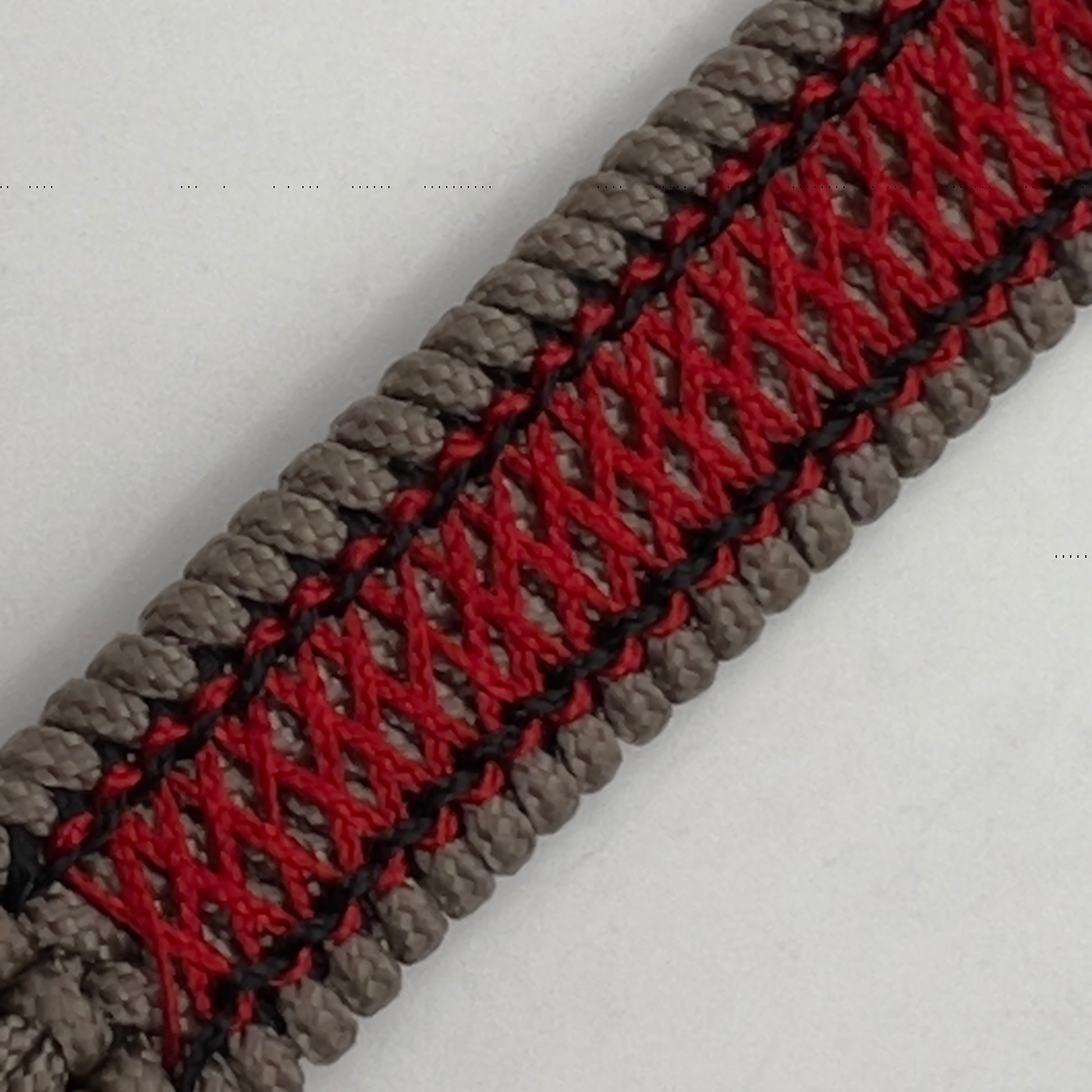 Thin, medium width, flexible and comfortable braided United States Marine Corps bracelet featuring a 24K antique gold plated USMC Eagle Globe and Anchor medallion, a gold Cobra style tactical buckle and woven with Tan Type-1 paracord and Imperial Red and Black nano cord.