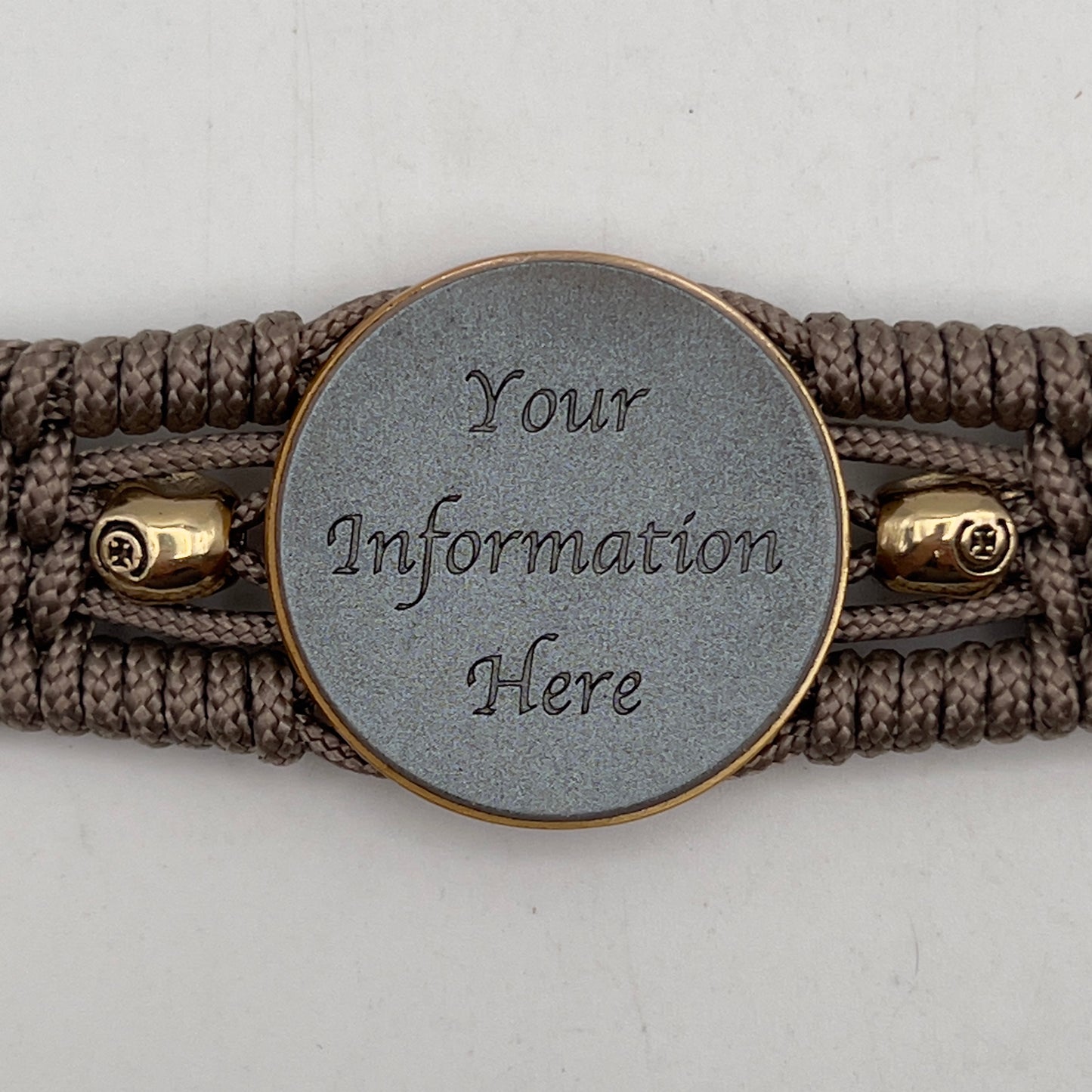 Thin, medium width, flexible and comfortable braided United States Marine Corps bracelet featuring a 24K antique gold plated USMC officer Eagle Globe and Anchor medallion, two gold plated skulls, a gold Cobra style tactical buckle and woven with tan Type-1 paracord.